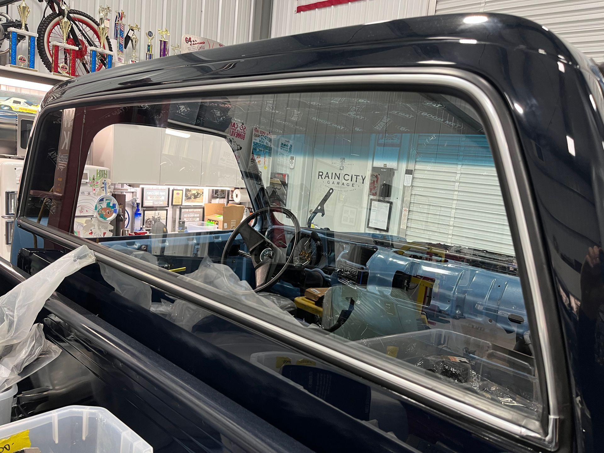A truck with a broken windshield is sitting in a garage.