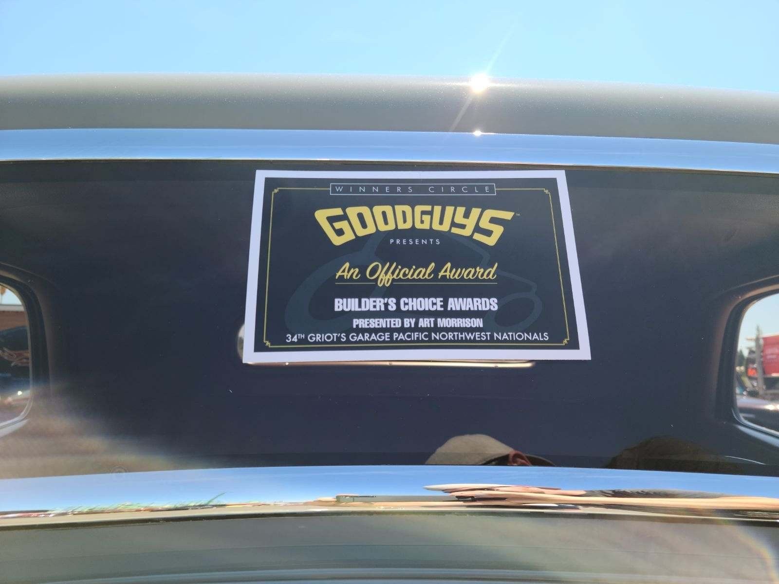 A sign on the windshield of a car that says goodguys
