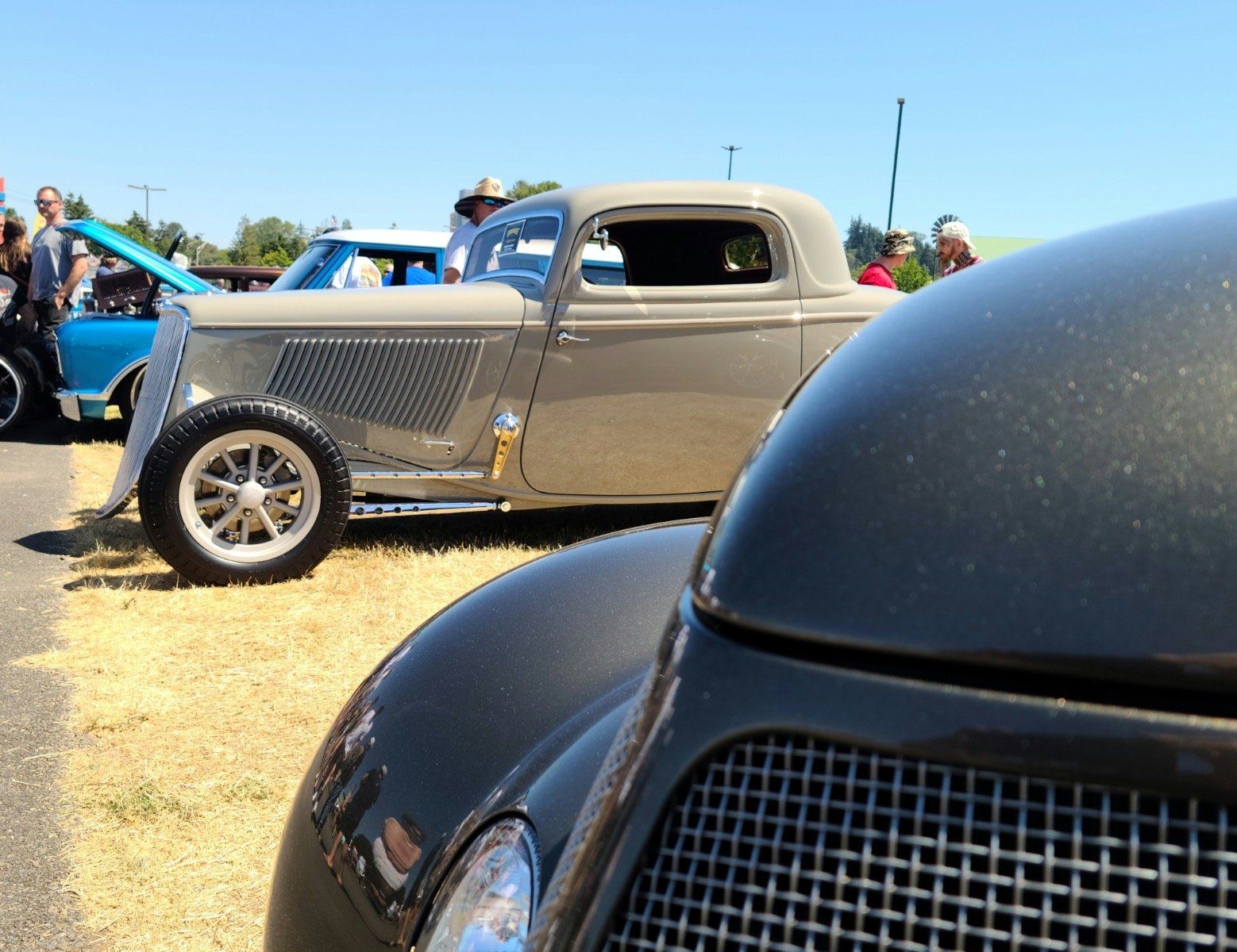 A gray car is parked next to a black car
