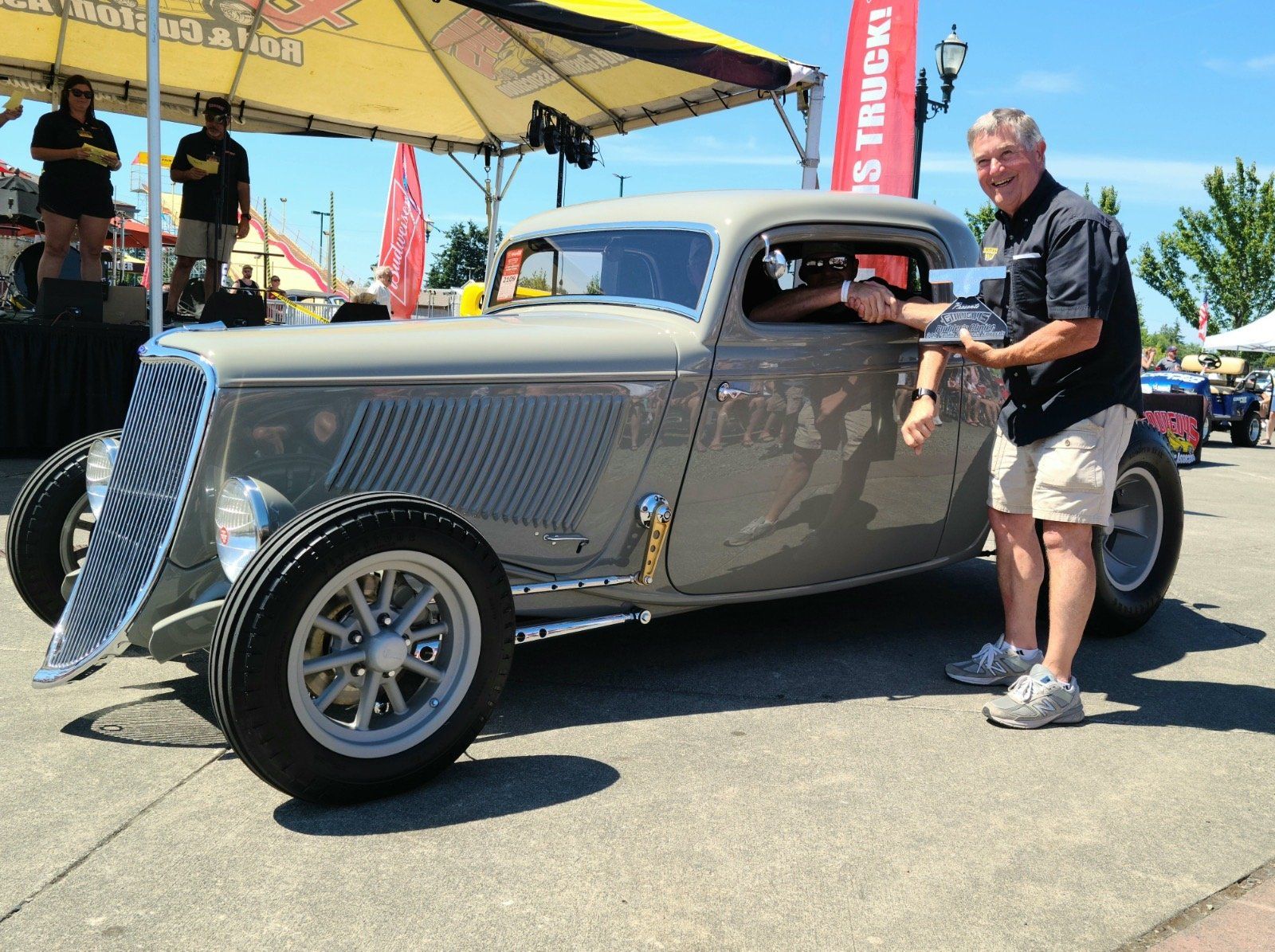 A man standing next to a car with a sign that says ' texas truck ' on it
