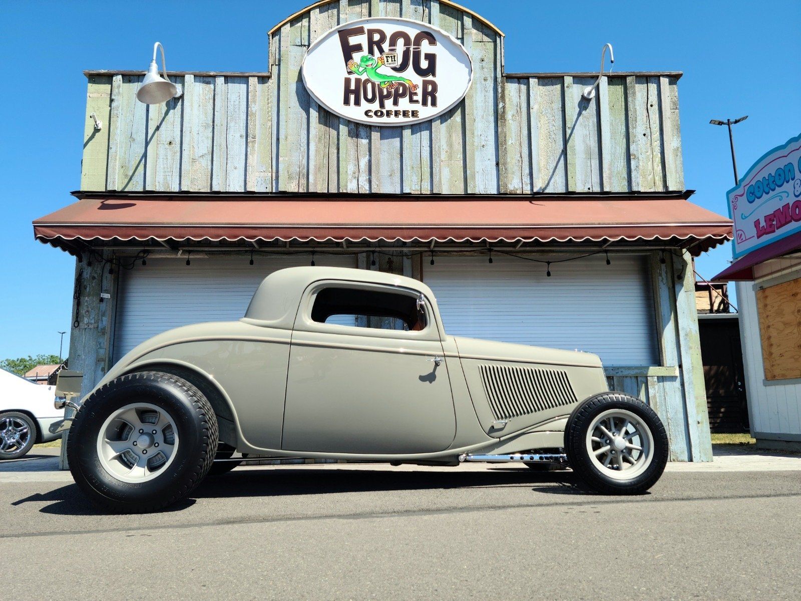 A car is parked in front of a building that says frog hopper coffee