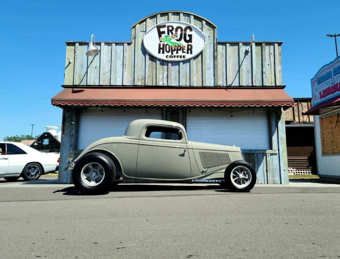 A car is parked in front of a building that says frog hopper