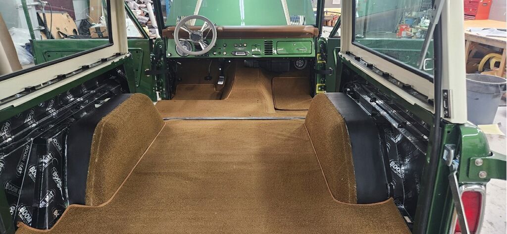 The interior of a green land rover is being remodeled.