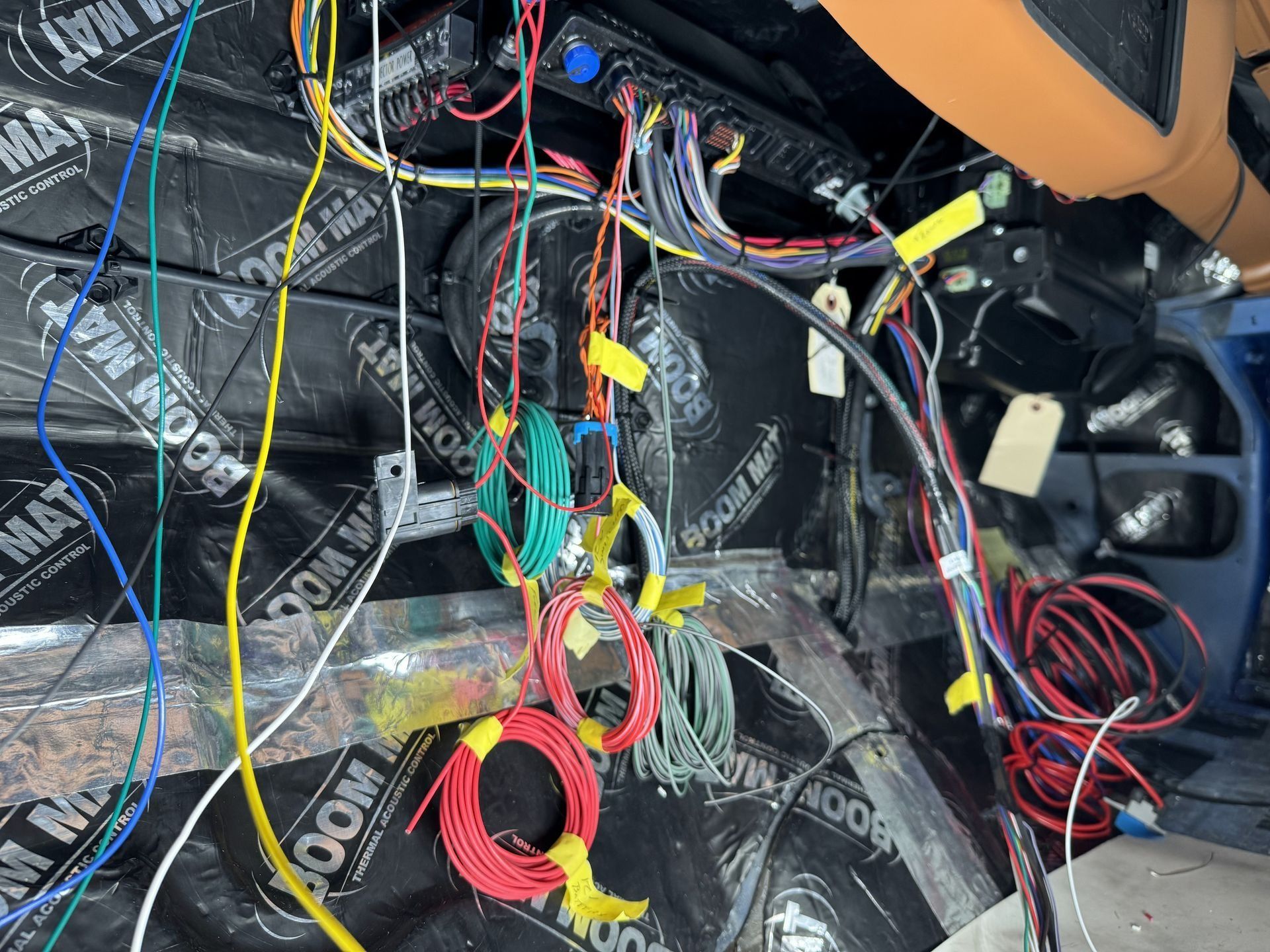 A bunch of wires are laying on the floor of a car.