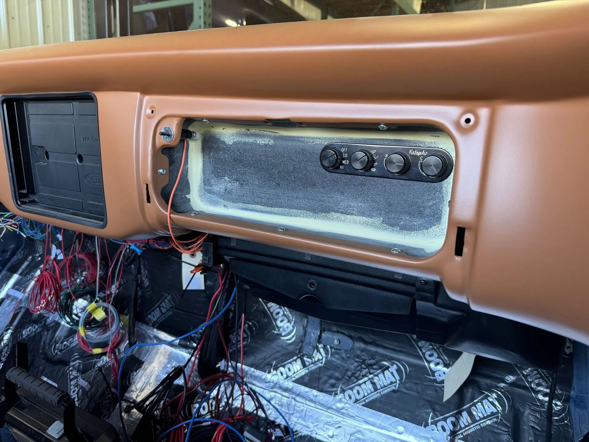 A dashboard of a car with a lot of wires coming out of it.