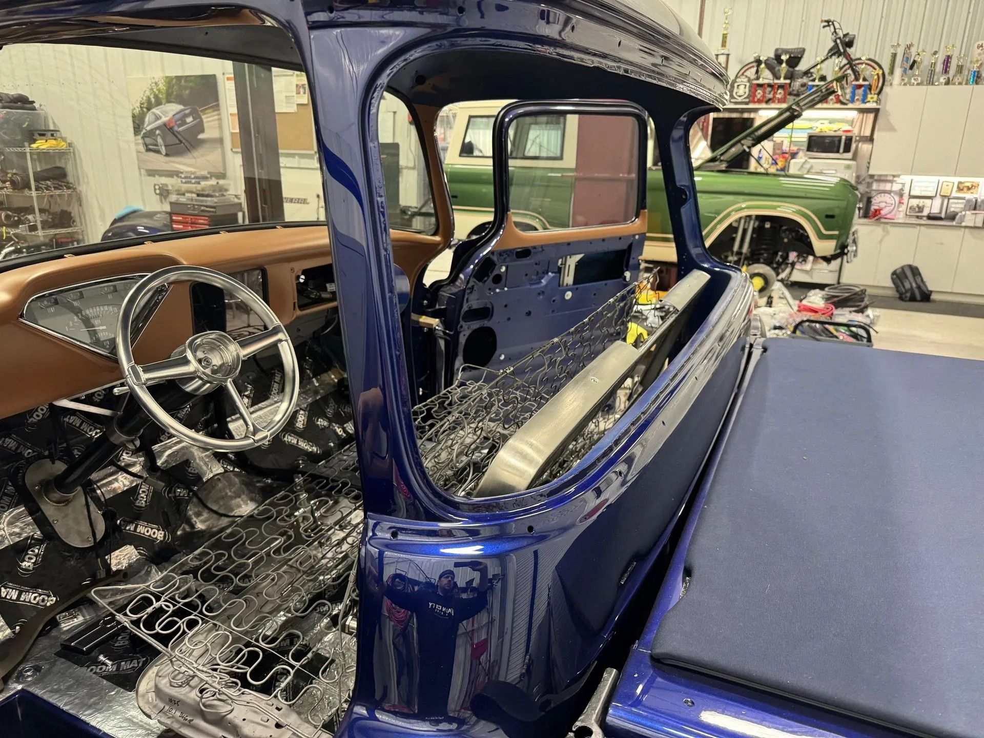 A blue truck is being built in a garage.