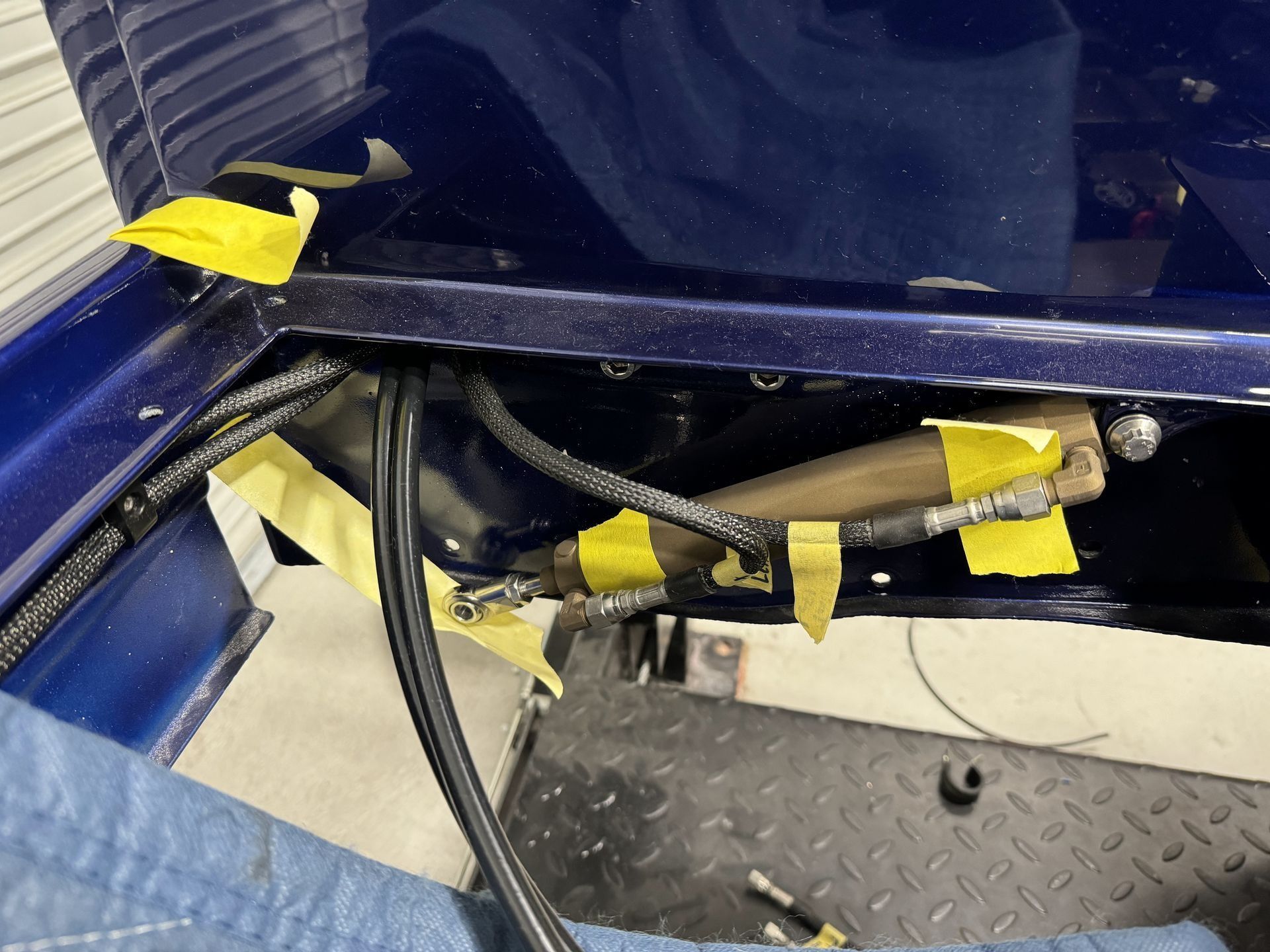 A hose is taped to the side of a blue car