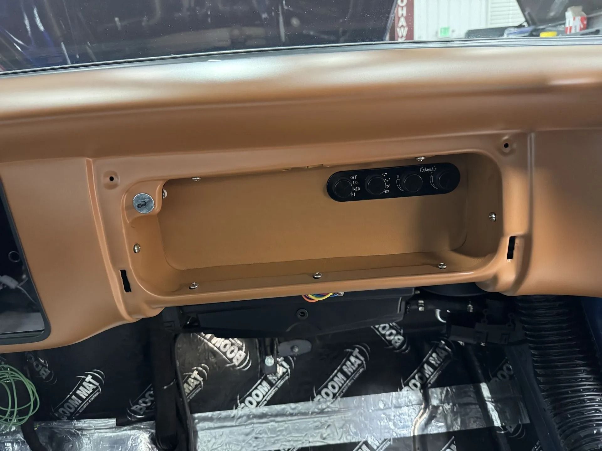 A close up of a car dashboard with the glove box open