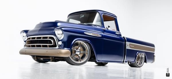 A blue pickup truck is parked on a white surface.