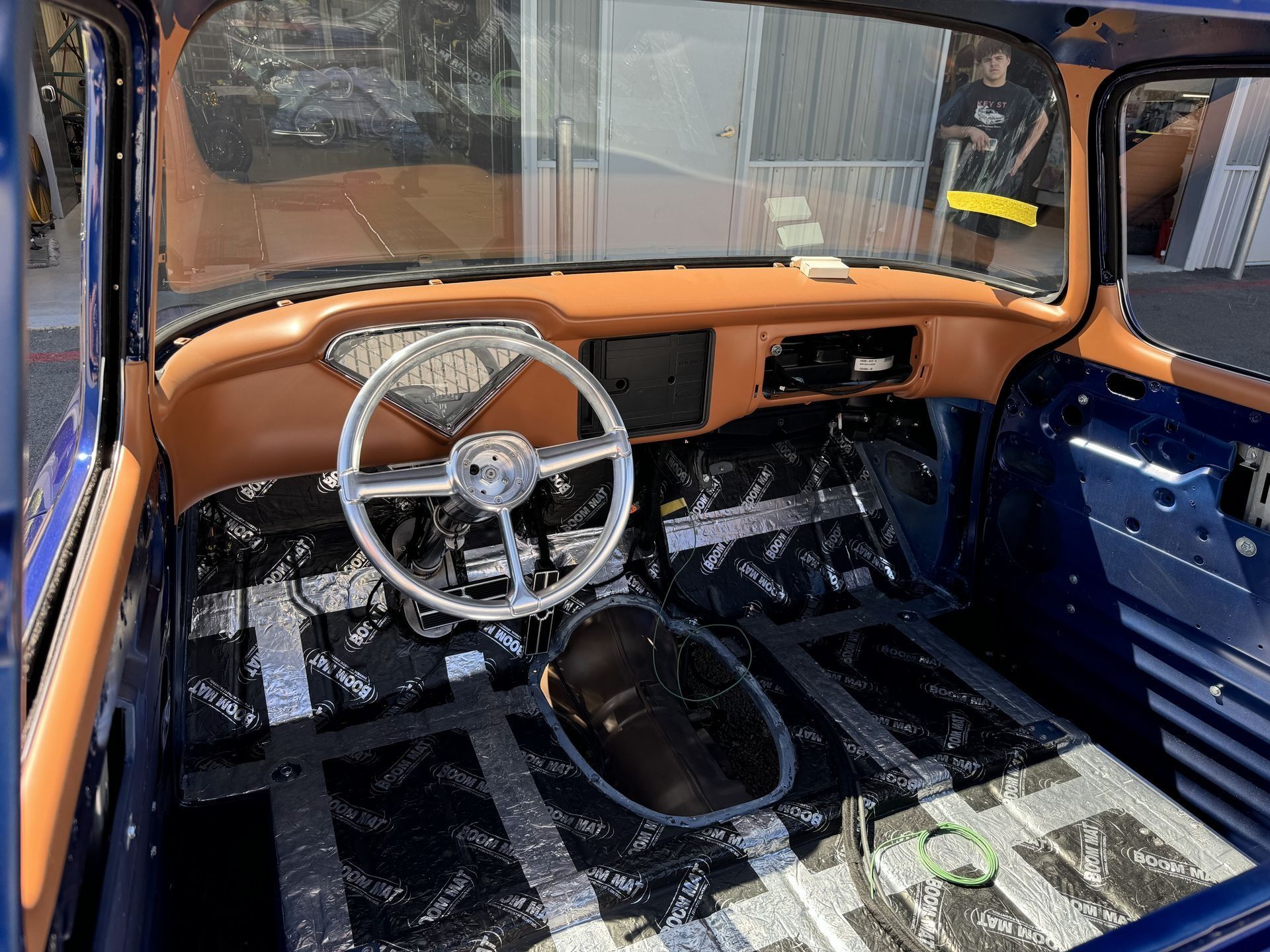 The interior of a blue truck with a steering wheel and dashboard.