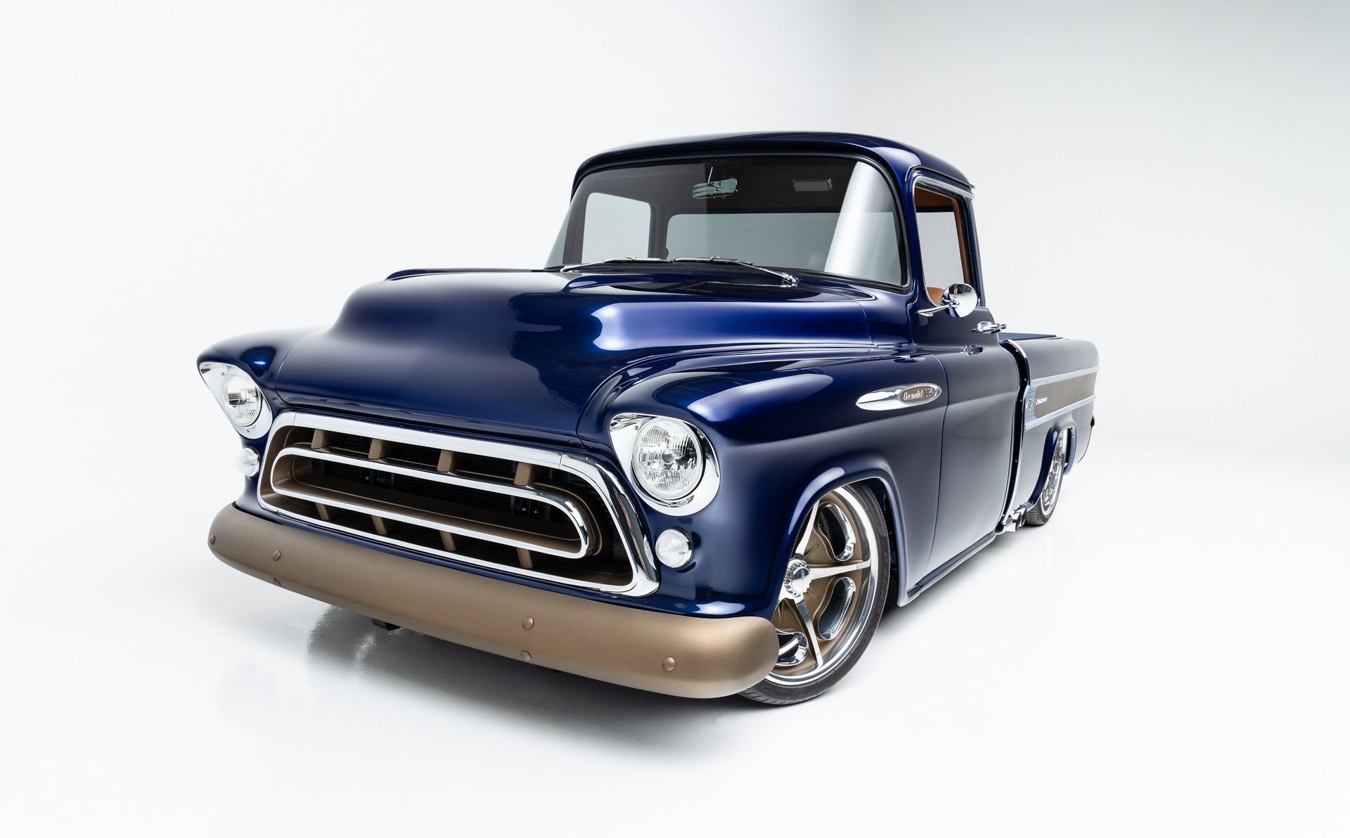 A blue pickup truck is parked on a white surface.