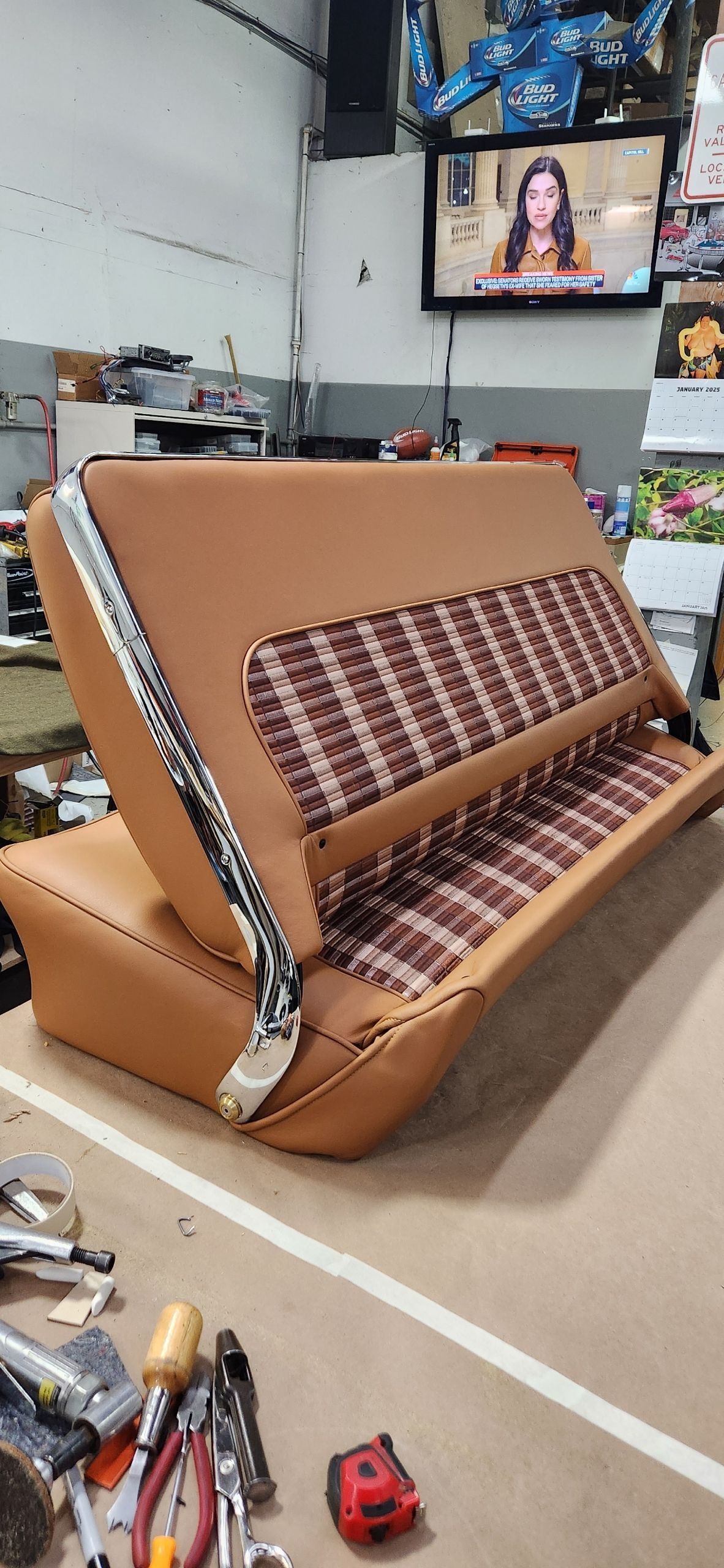 A brown couch is sitting in a room next to a television.