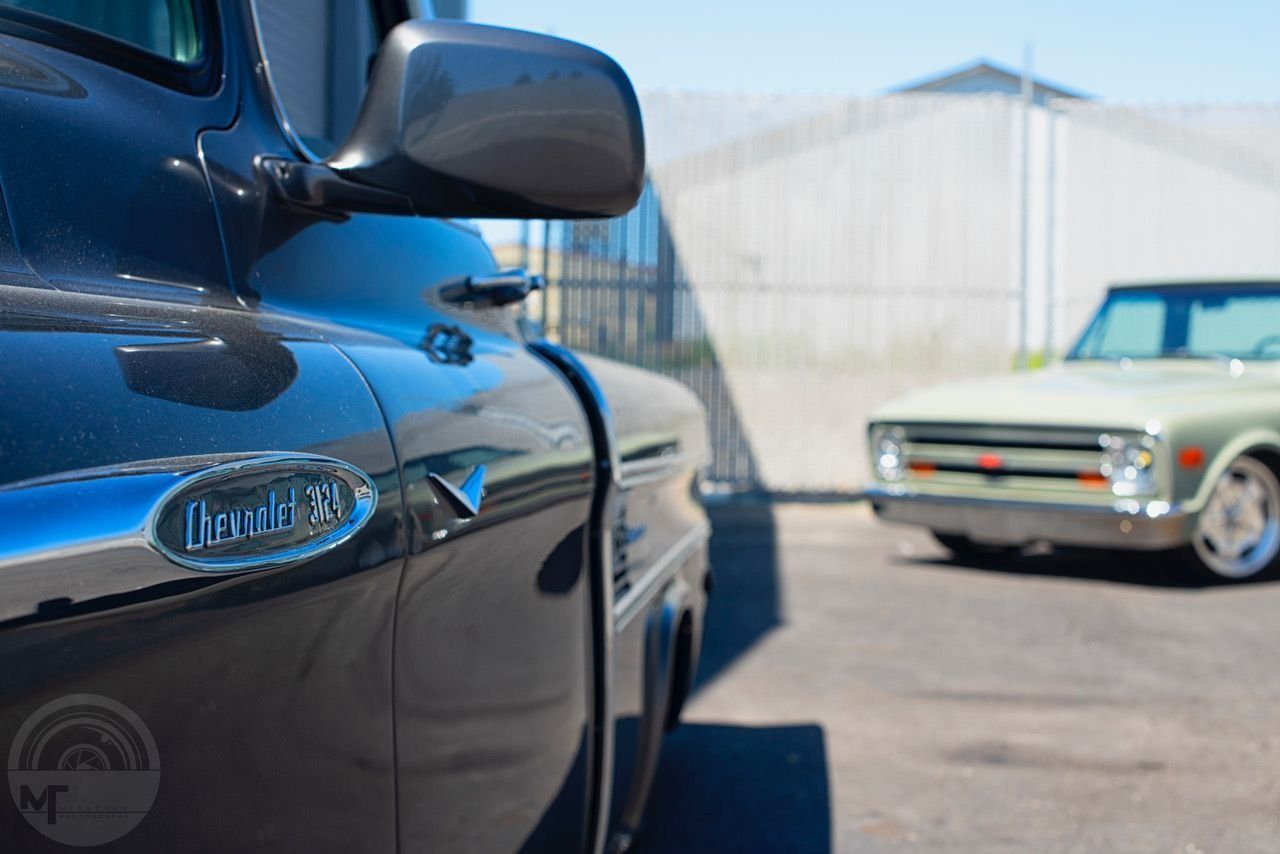 Two cars are parked next to each other in a parking lot.