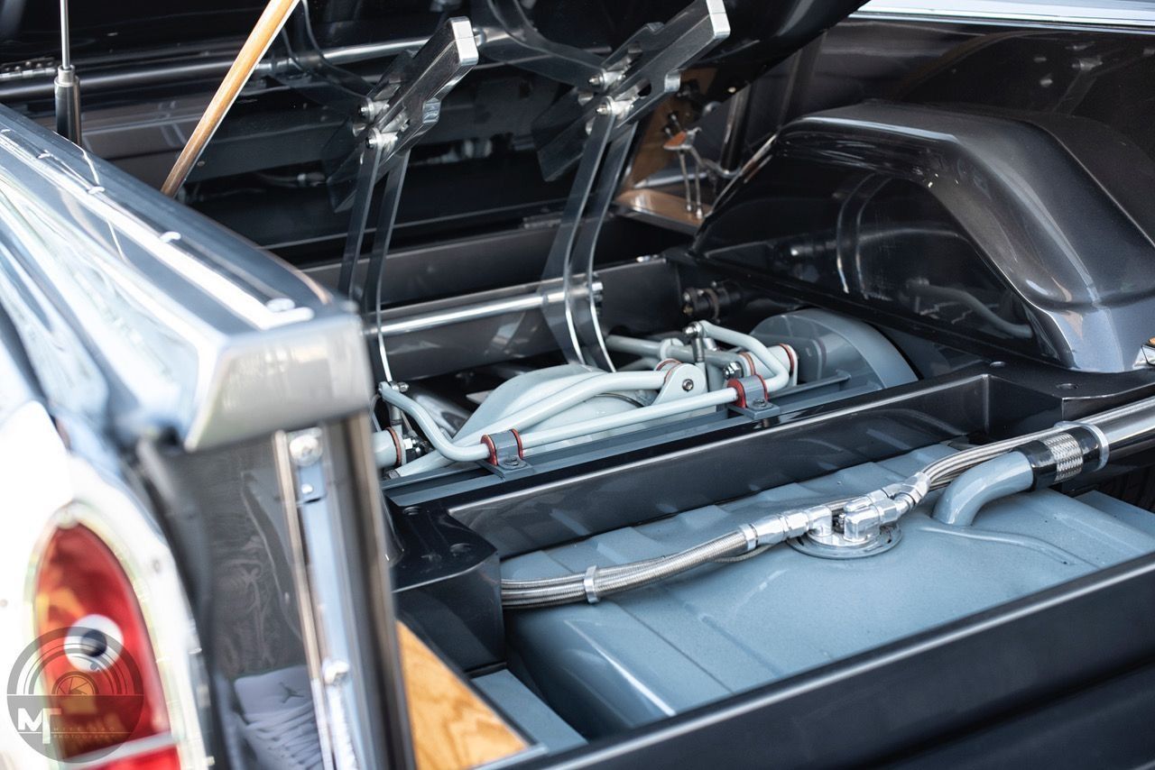 The back of a car with the trunk open and a fuel tank.