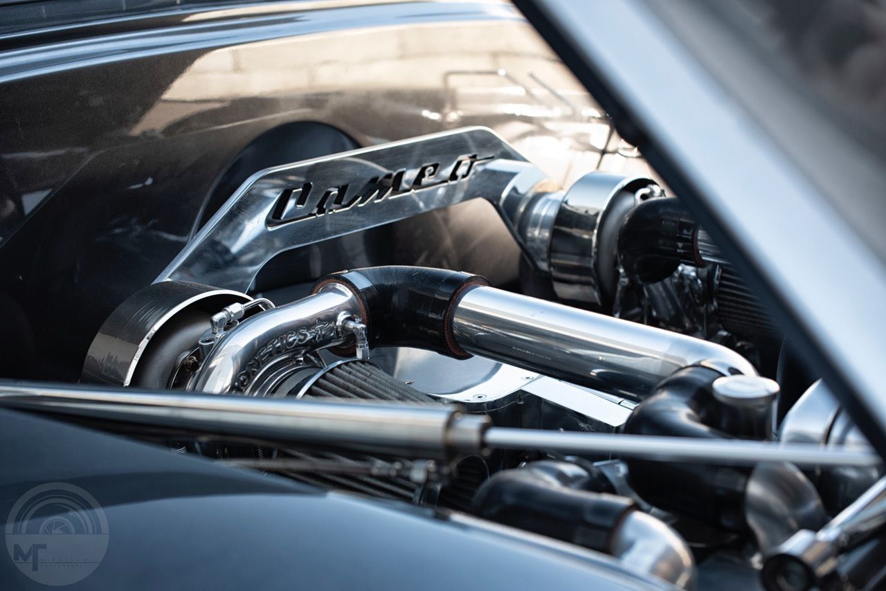 A close up of a car engine with the hood open