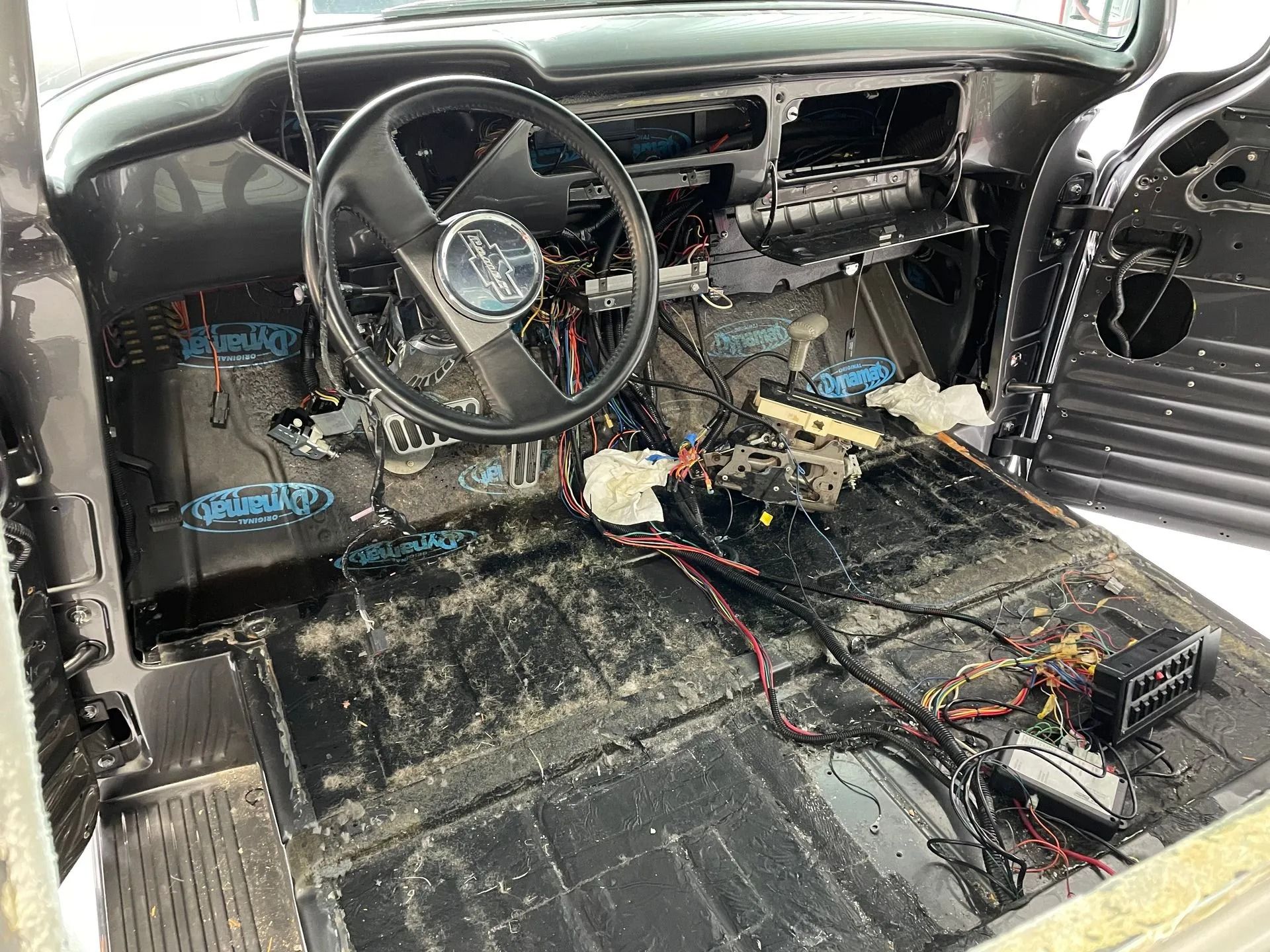 The inside of a car with a steering wheel and a dashboard.