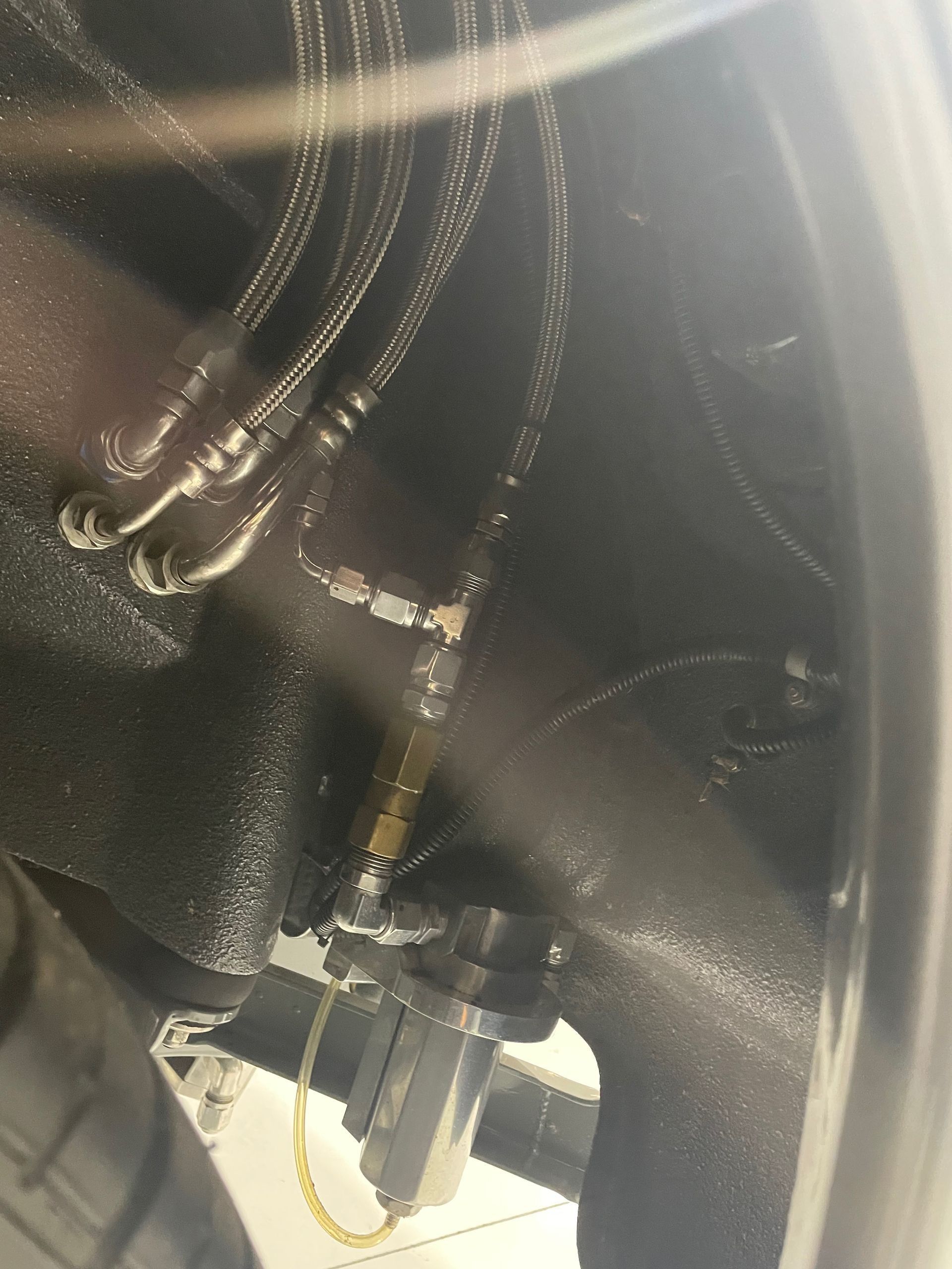 A close up of a hose on the underside of a car.