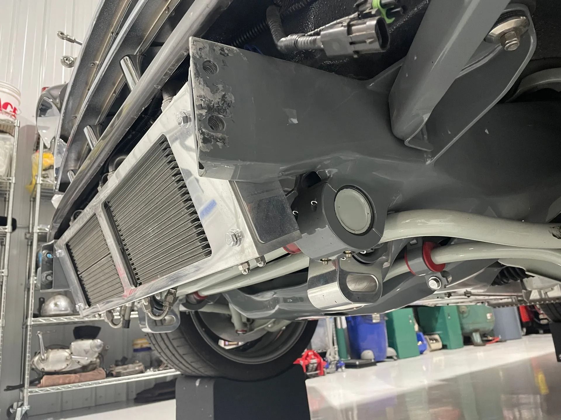 A car with a radiator underneath it in a garage.