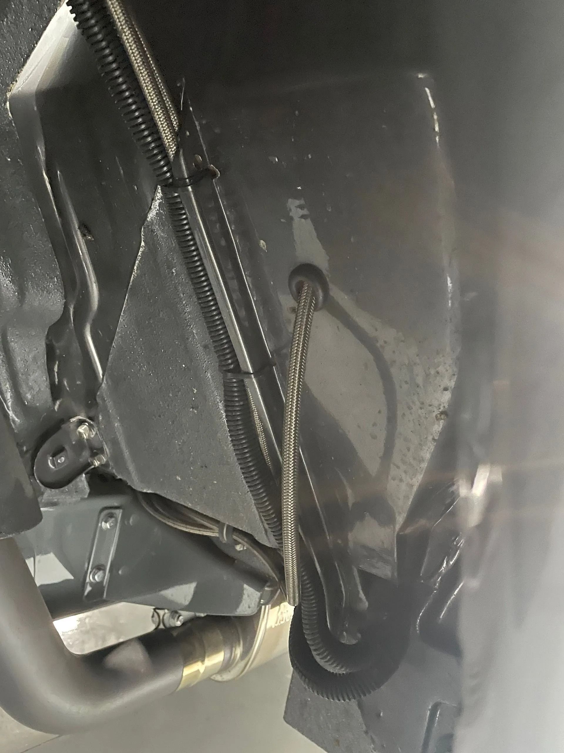 A close up of the underside of a car with smoke coming out of it