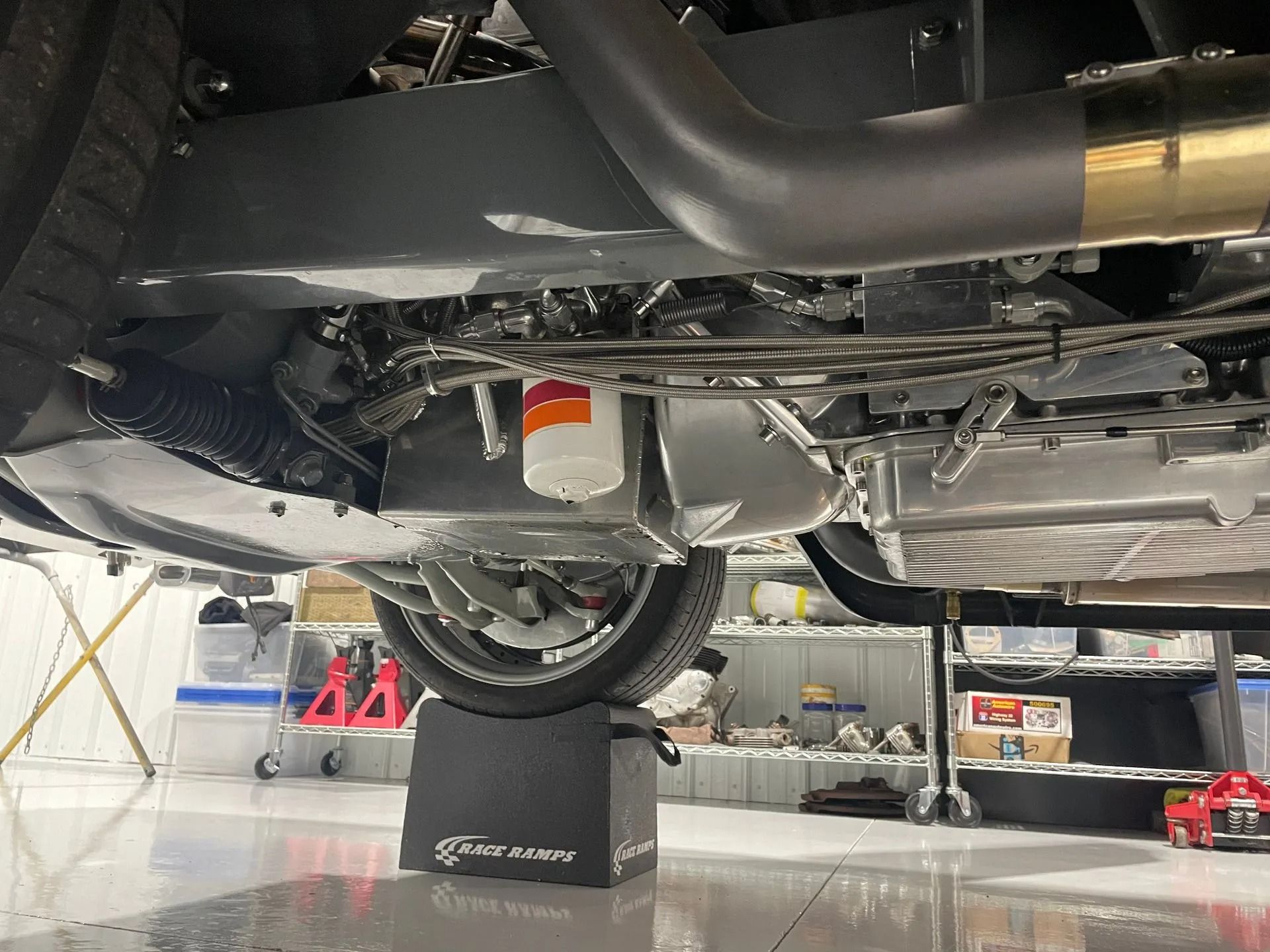 The underside of a car is shown in a garage