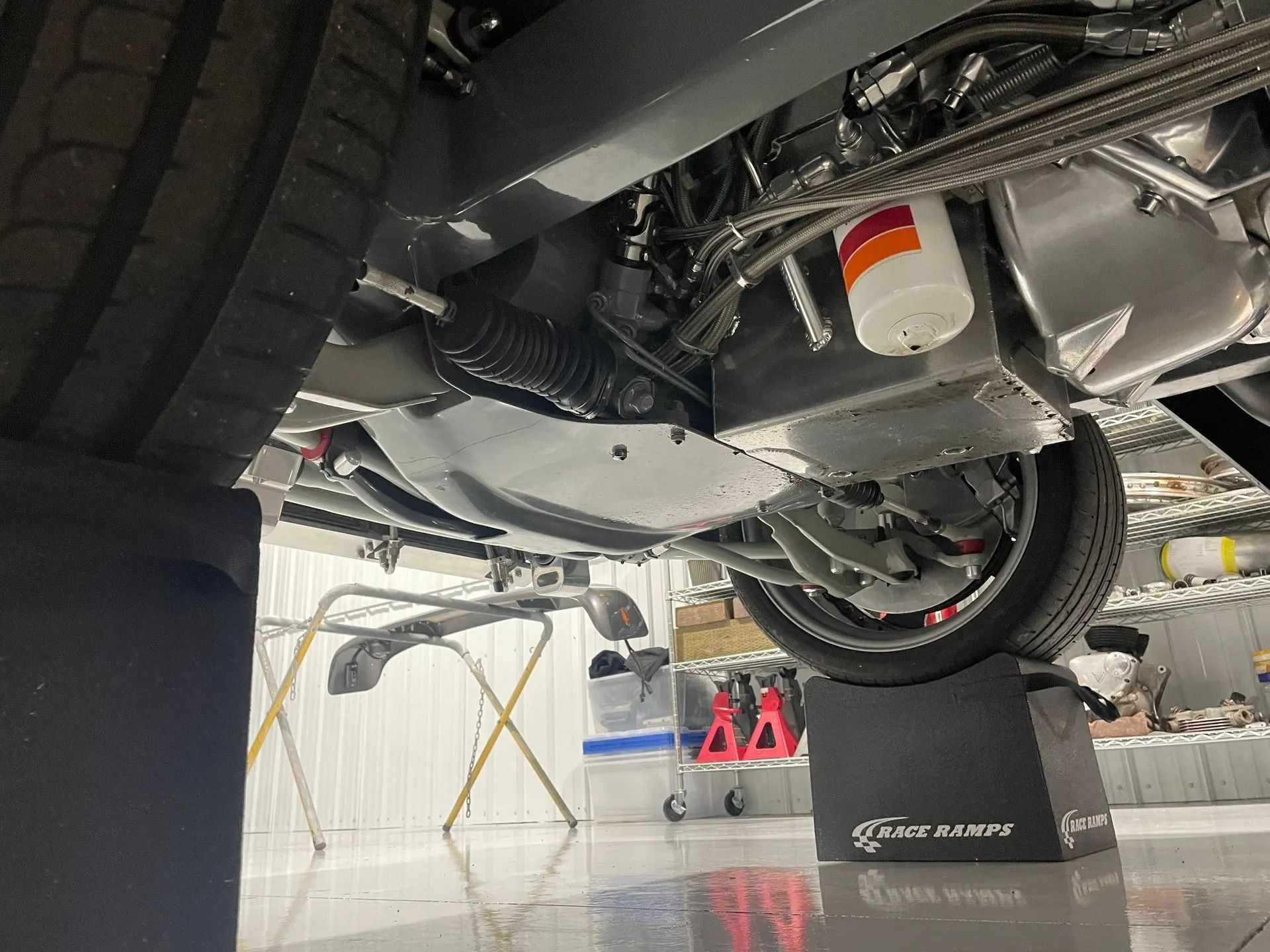 A car is sitting on a lift in a garage.