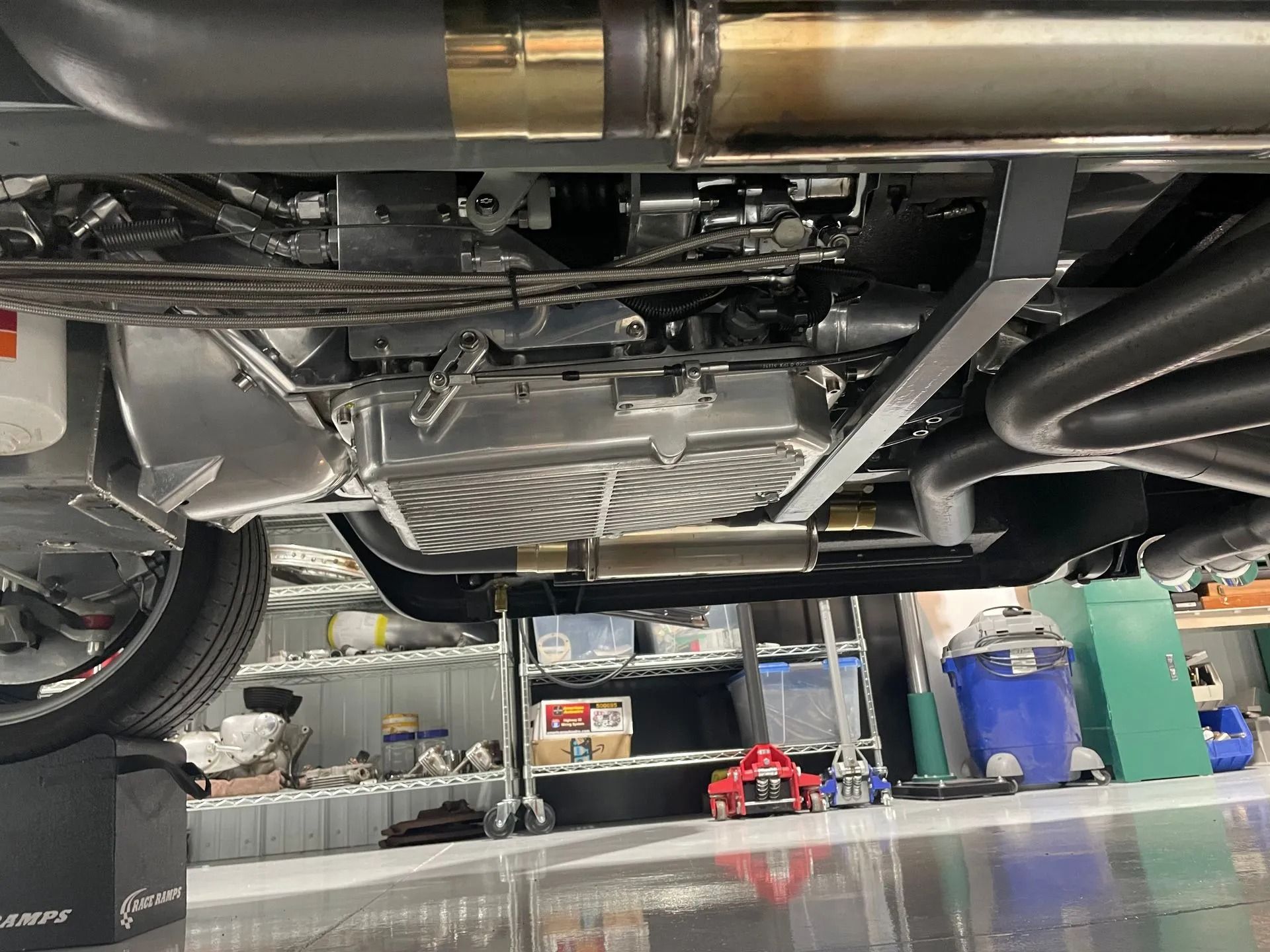 The underside of a car is shown in a garage.