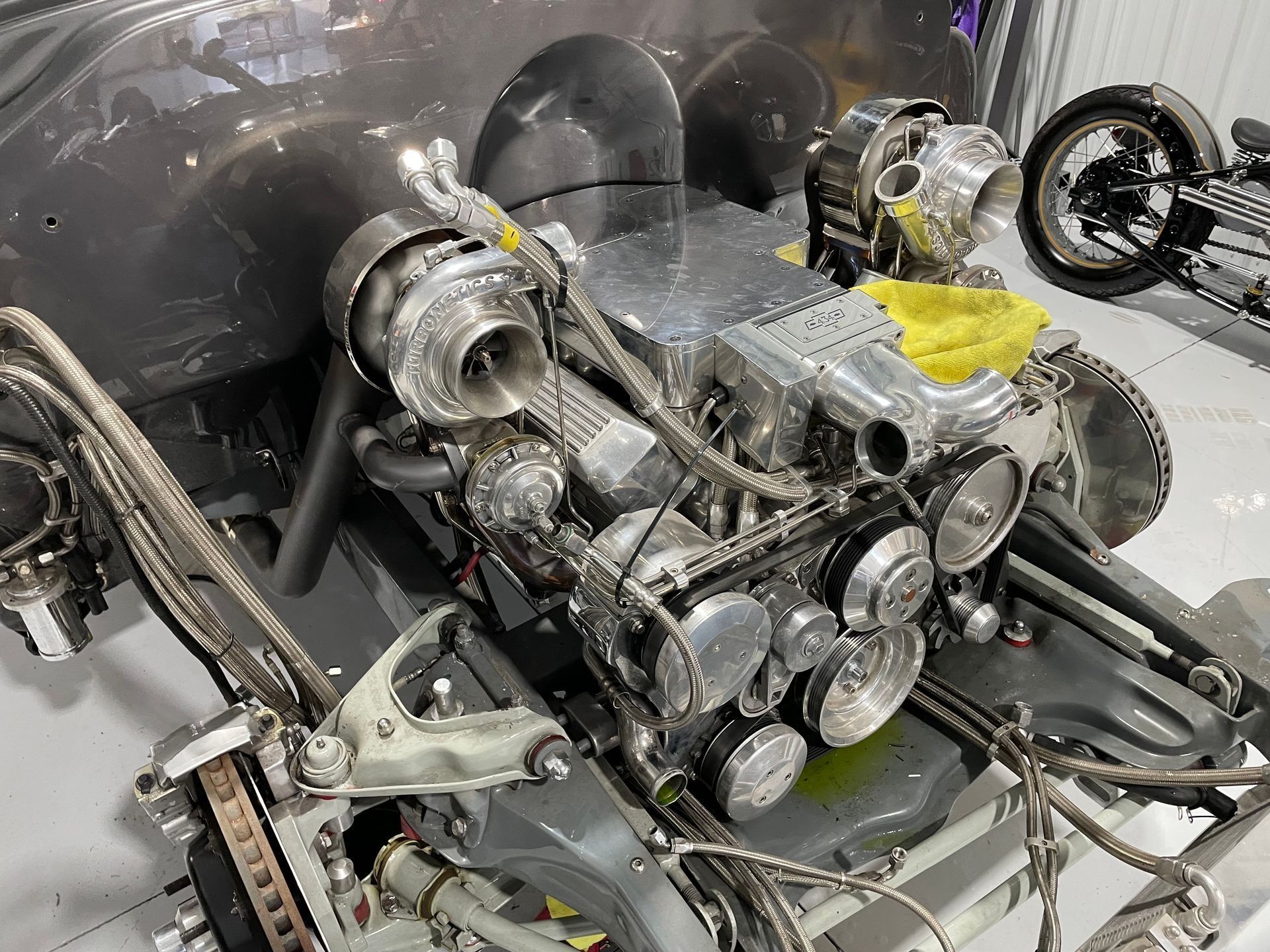 A close up of a car engine in a garage.