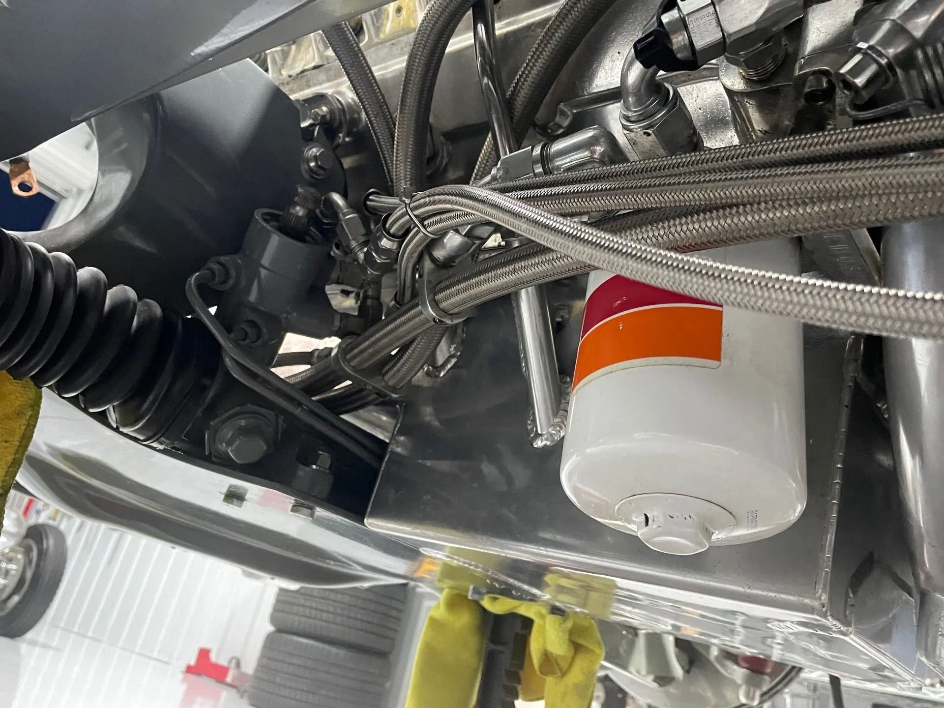 A close up of a car engine with a hose attached to it