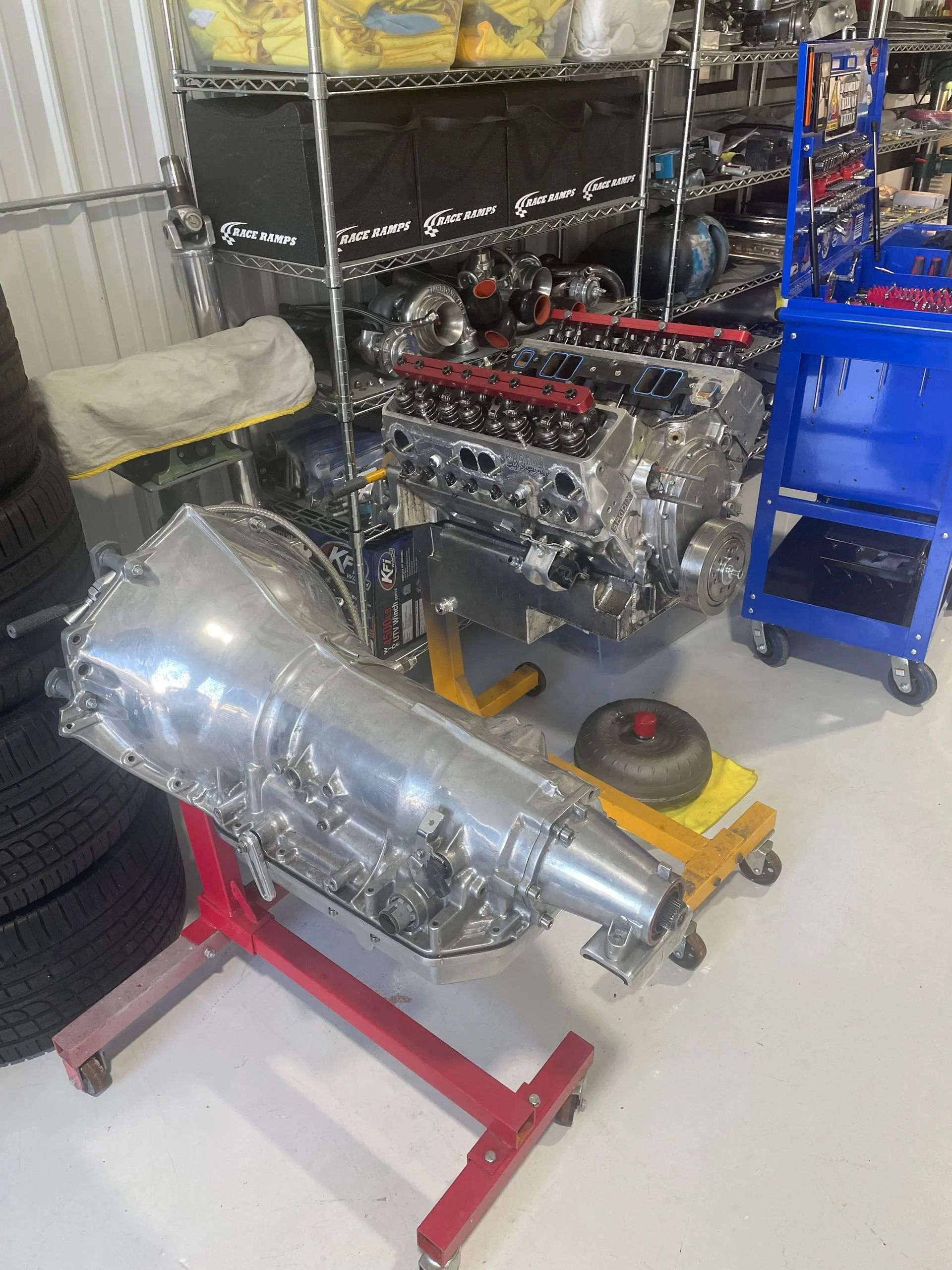 A car engine is sitting on a stand in a garage.