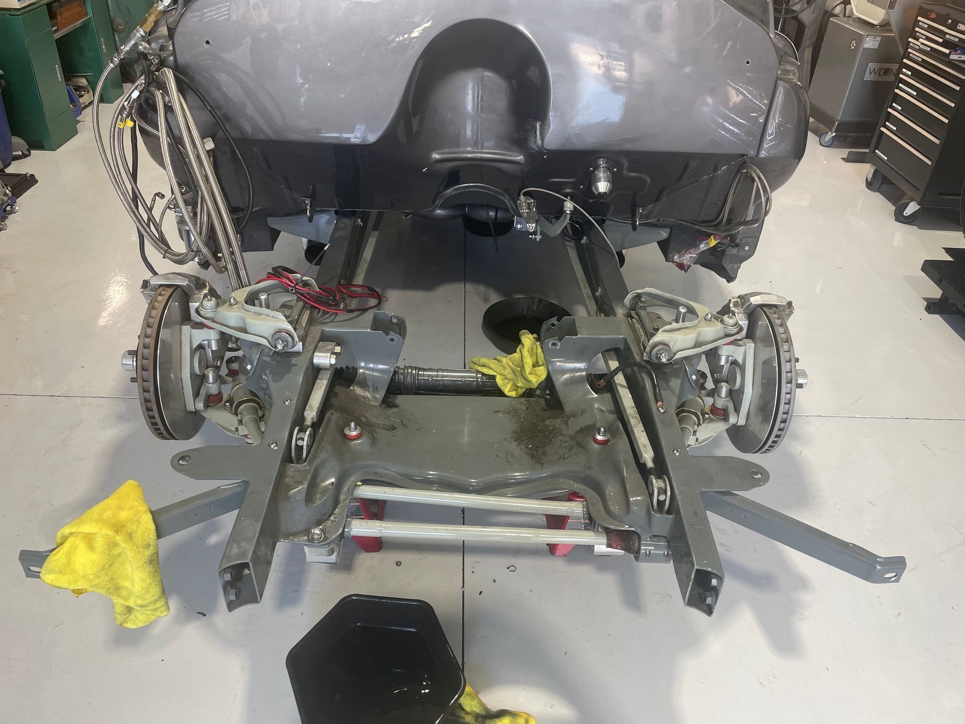 A gray car is being worked on in a garage