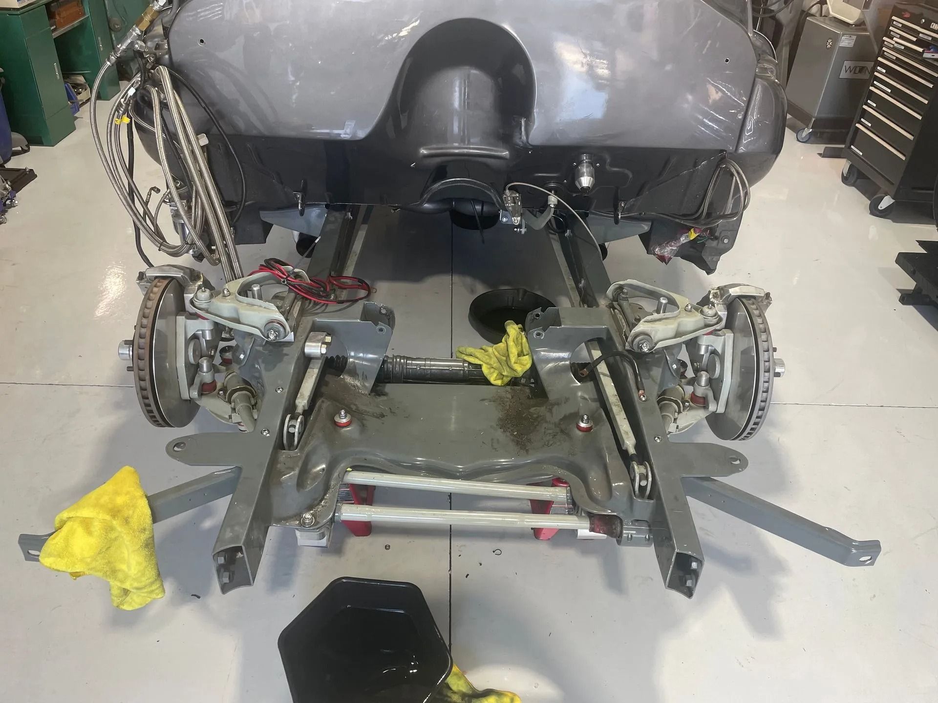 A gray car is being worked on in a garage