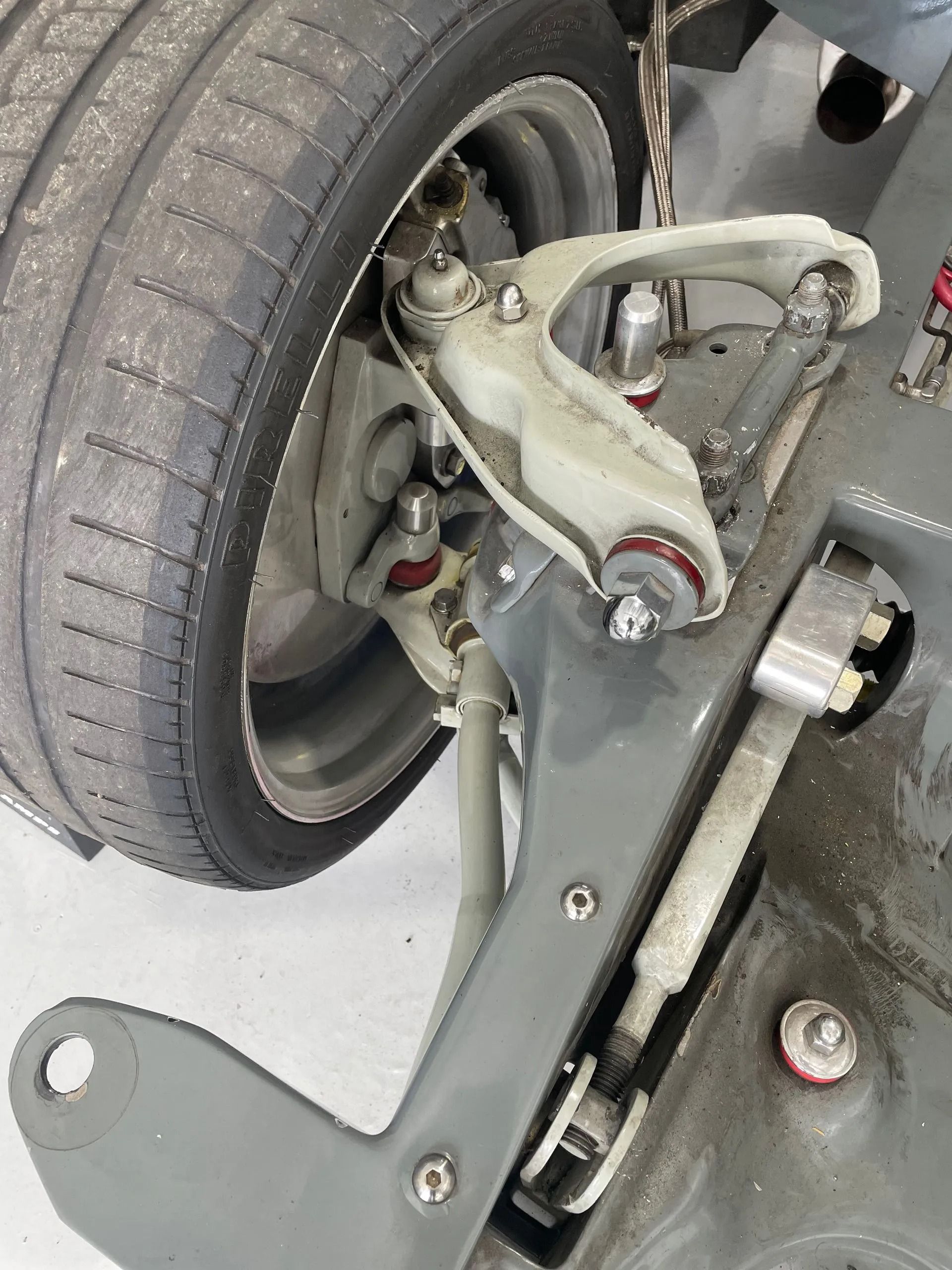 A close up of a car suspension with a tire in the background.