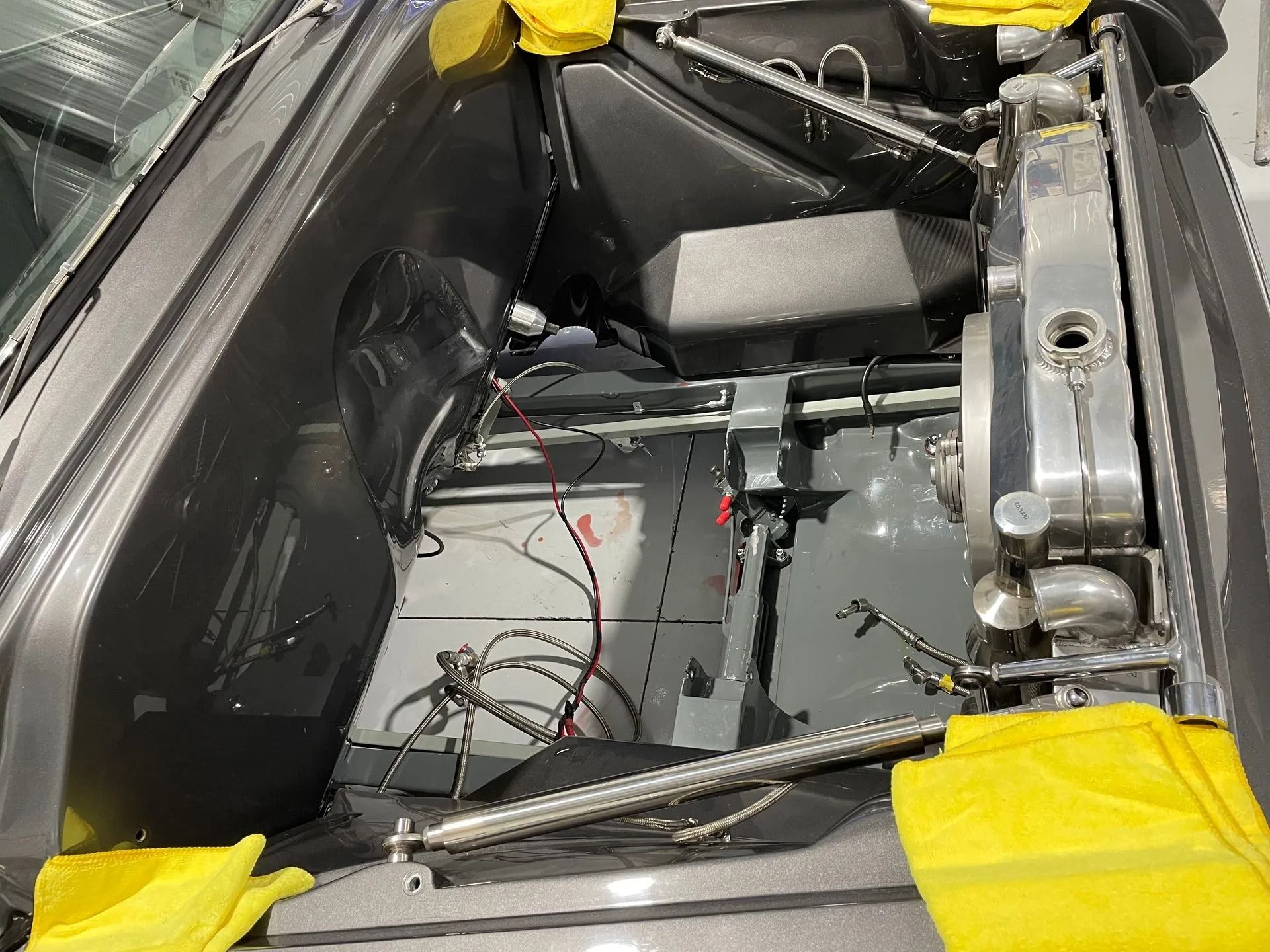 The inside of a car with a radiator and a battery.