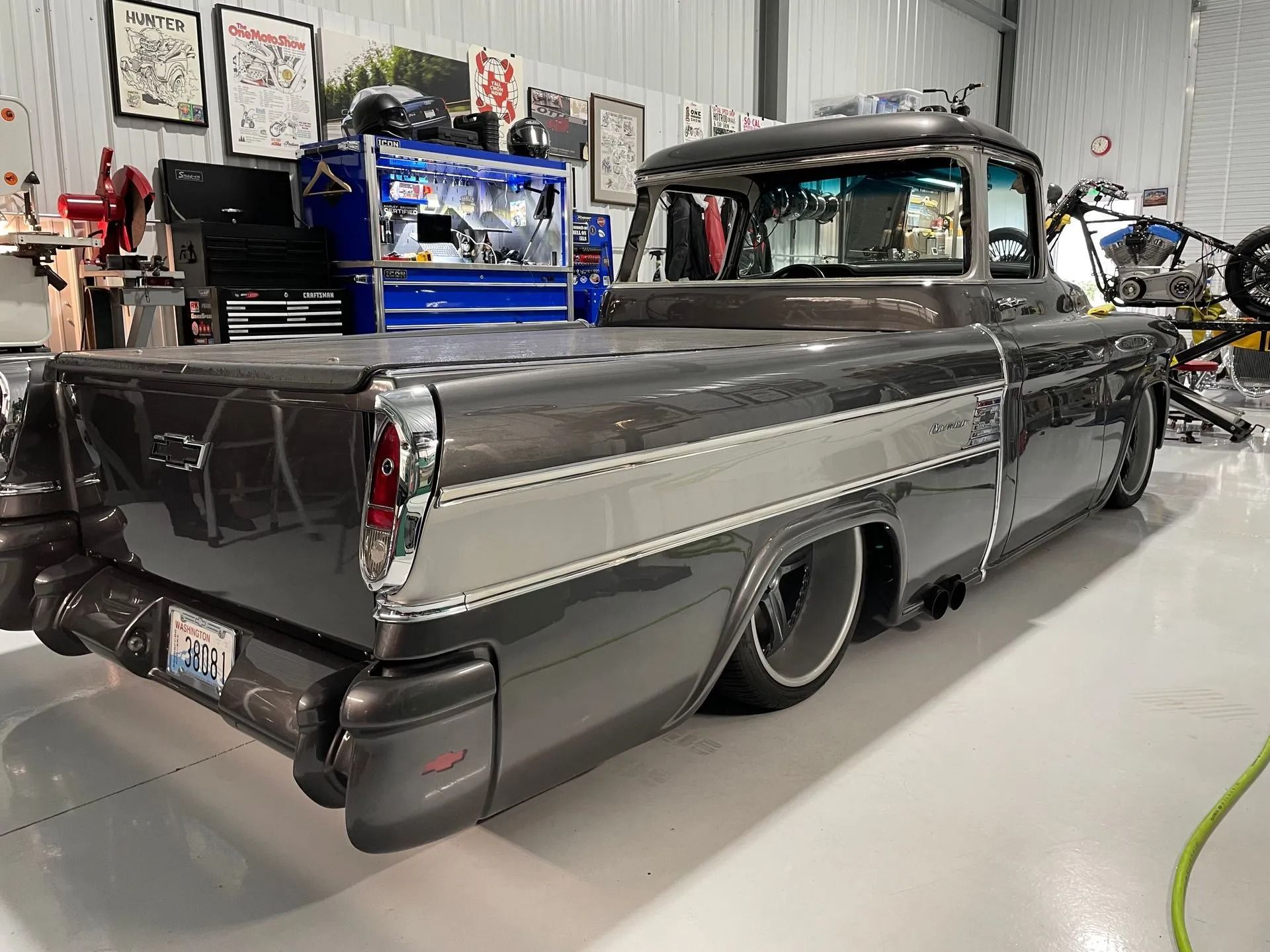 A black and silver truck is parked in a garage.