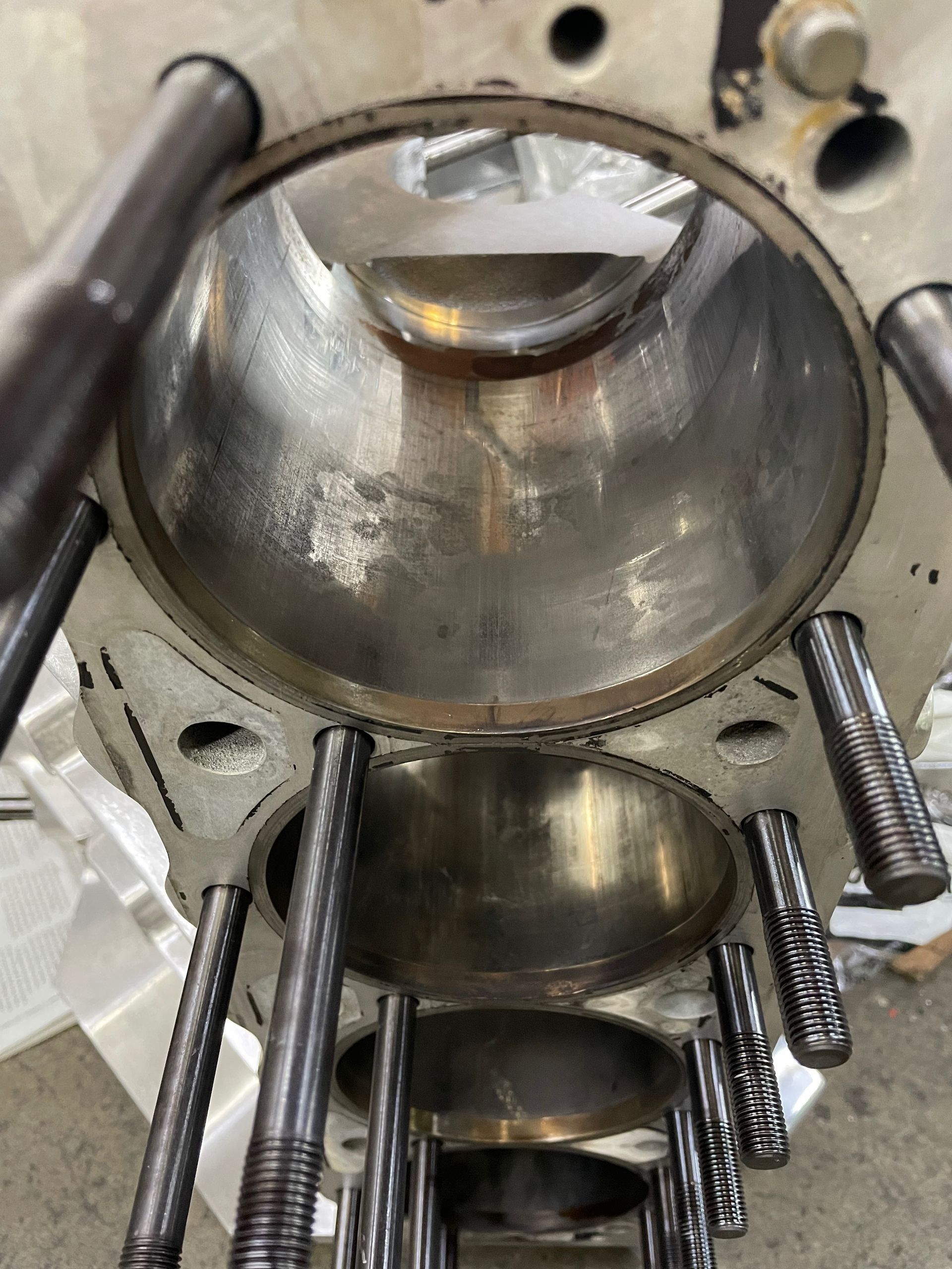 A close up of a cylinder block with screws coming out of it.