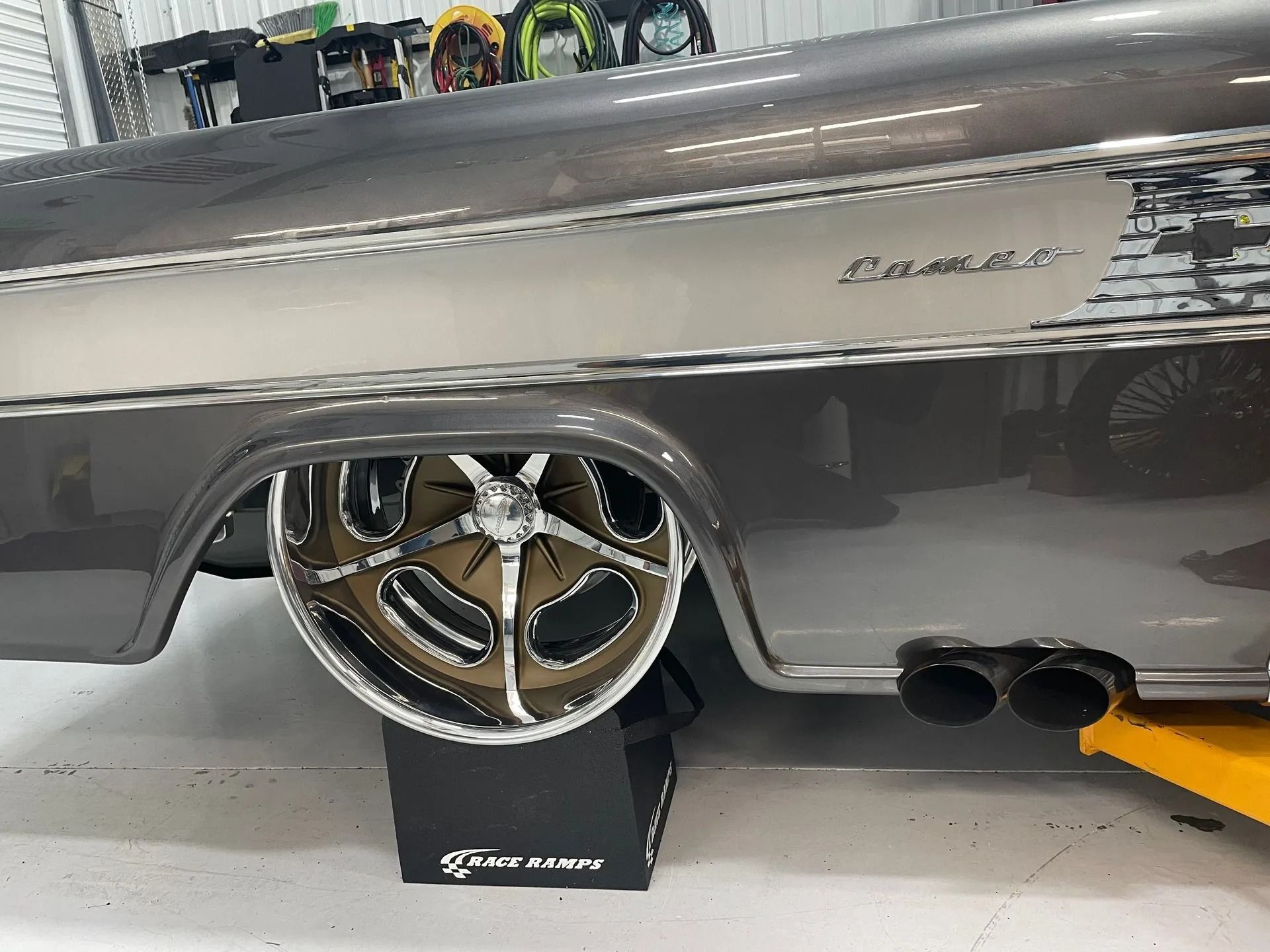 A car is sitting on a lift in a garage.