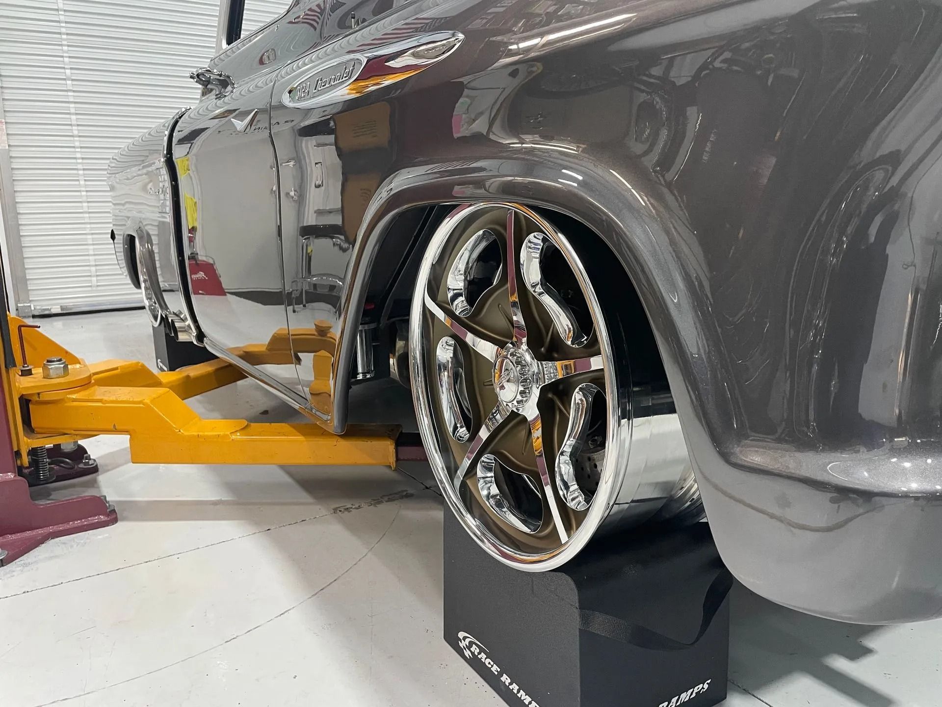 A car is sitting on a ramp in a garage.