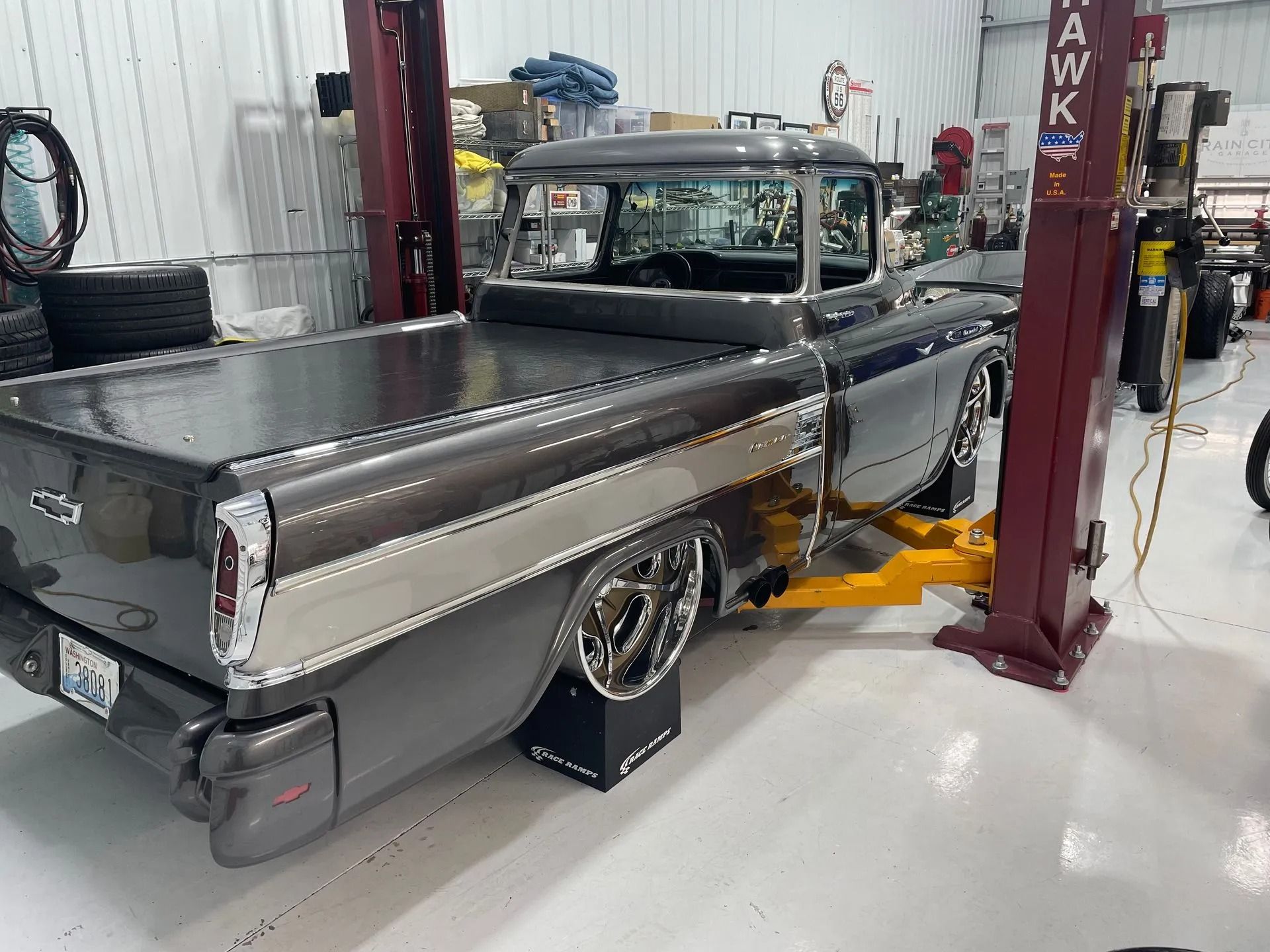 A truck is sitting on a lift in a garage.