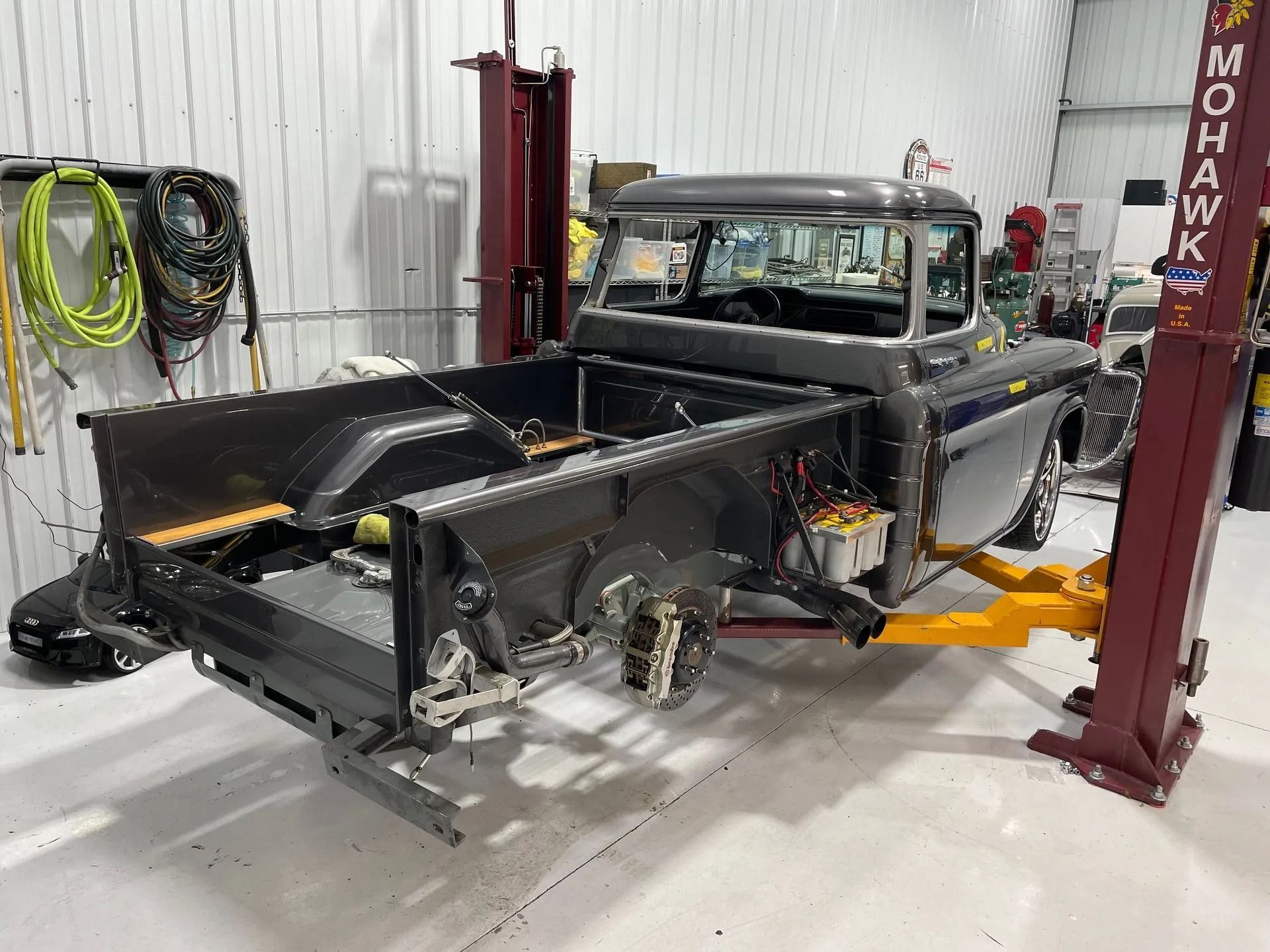 A truck is sitting on a lift in a garage.