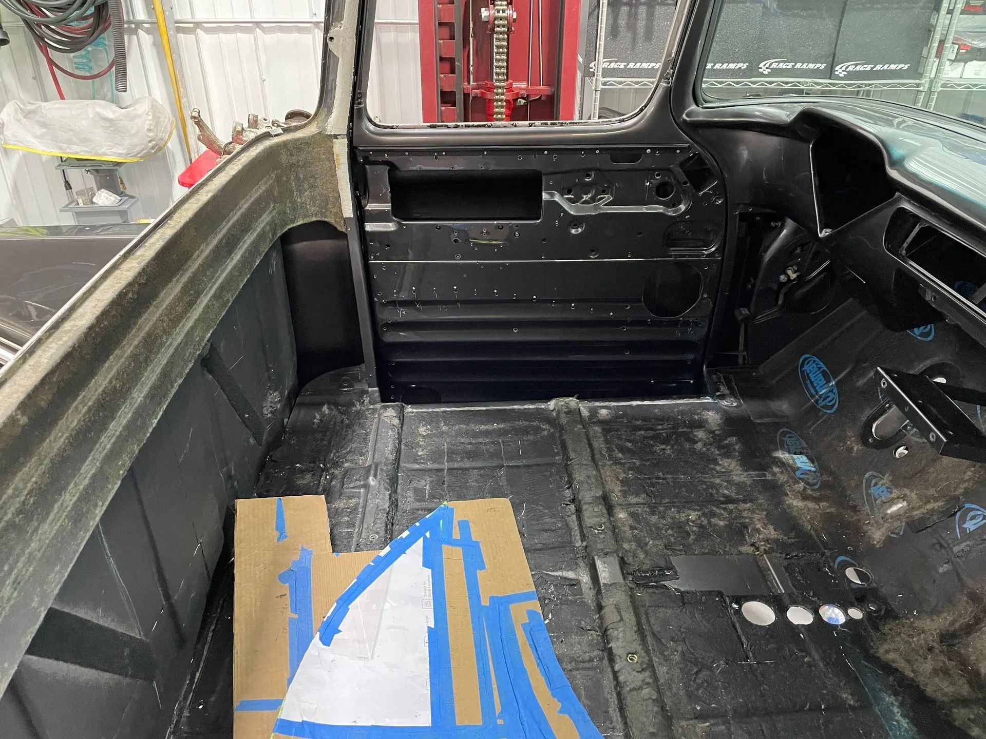 The inside of a car with a box of blue tape on the floor.