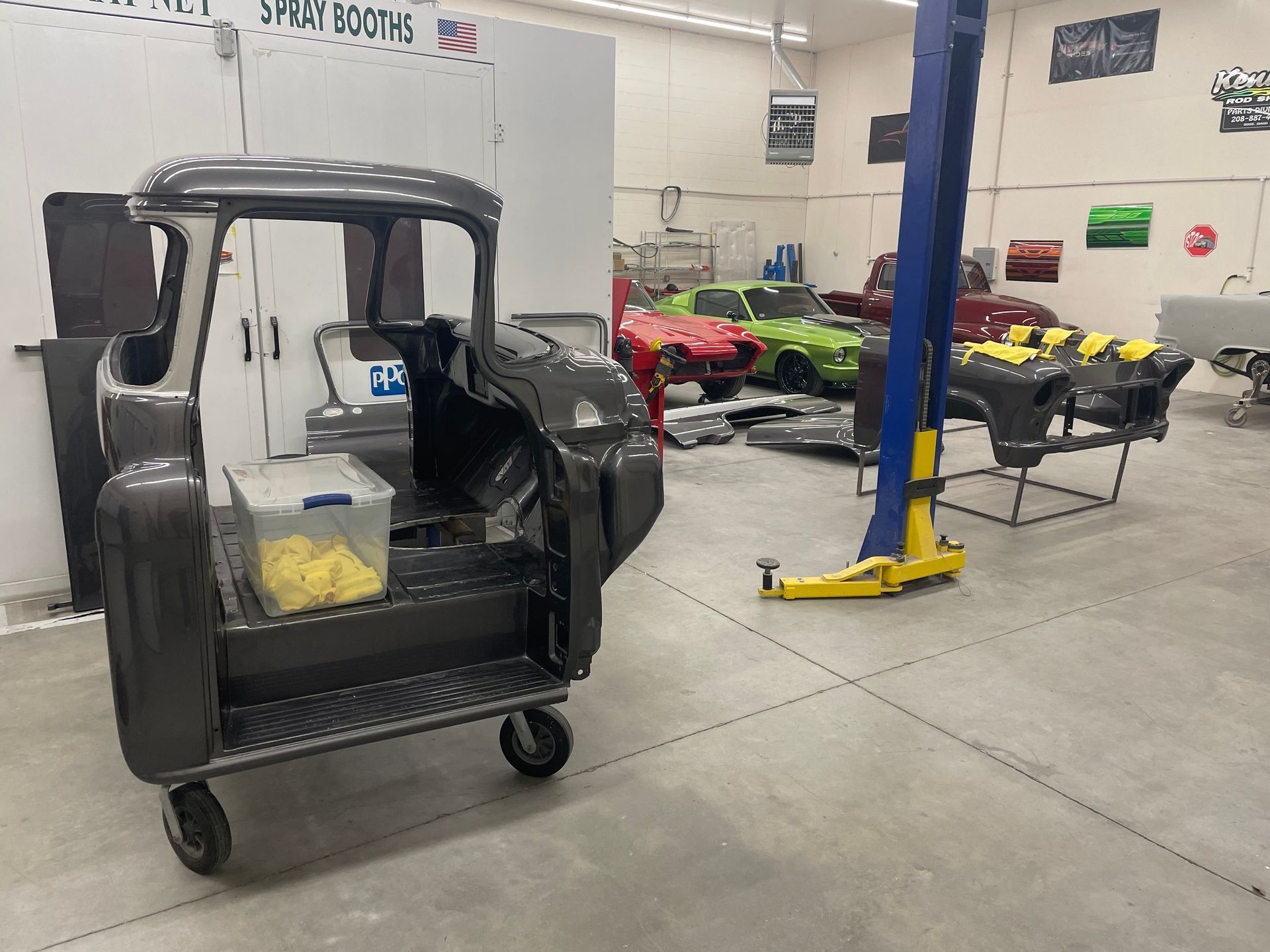 A truck is sitting on a cart in a garage next to a lift.