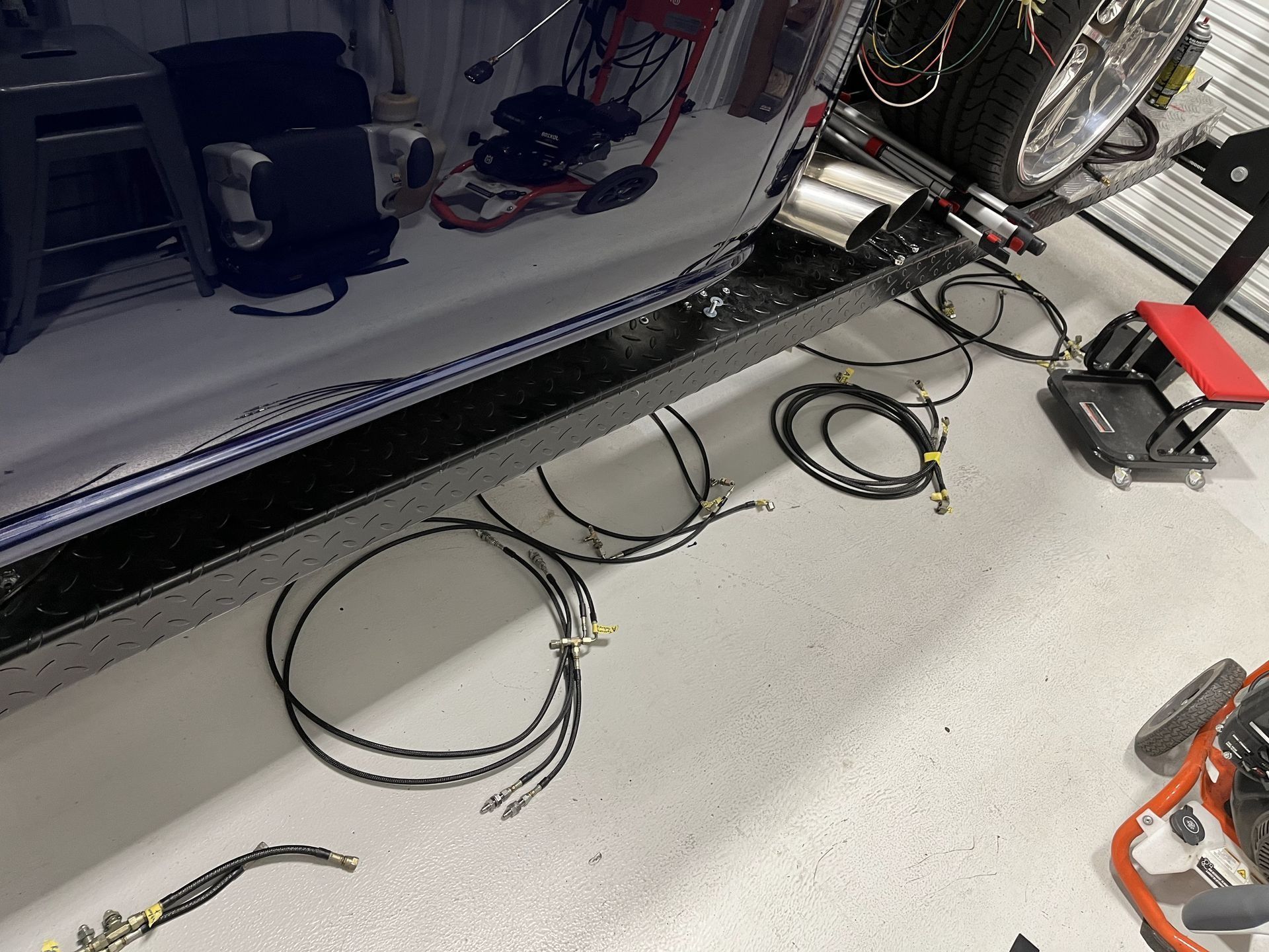 A bunch of wires are laying on the floor in a garage