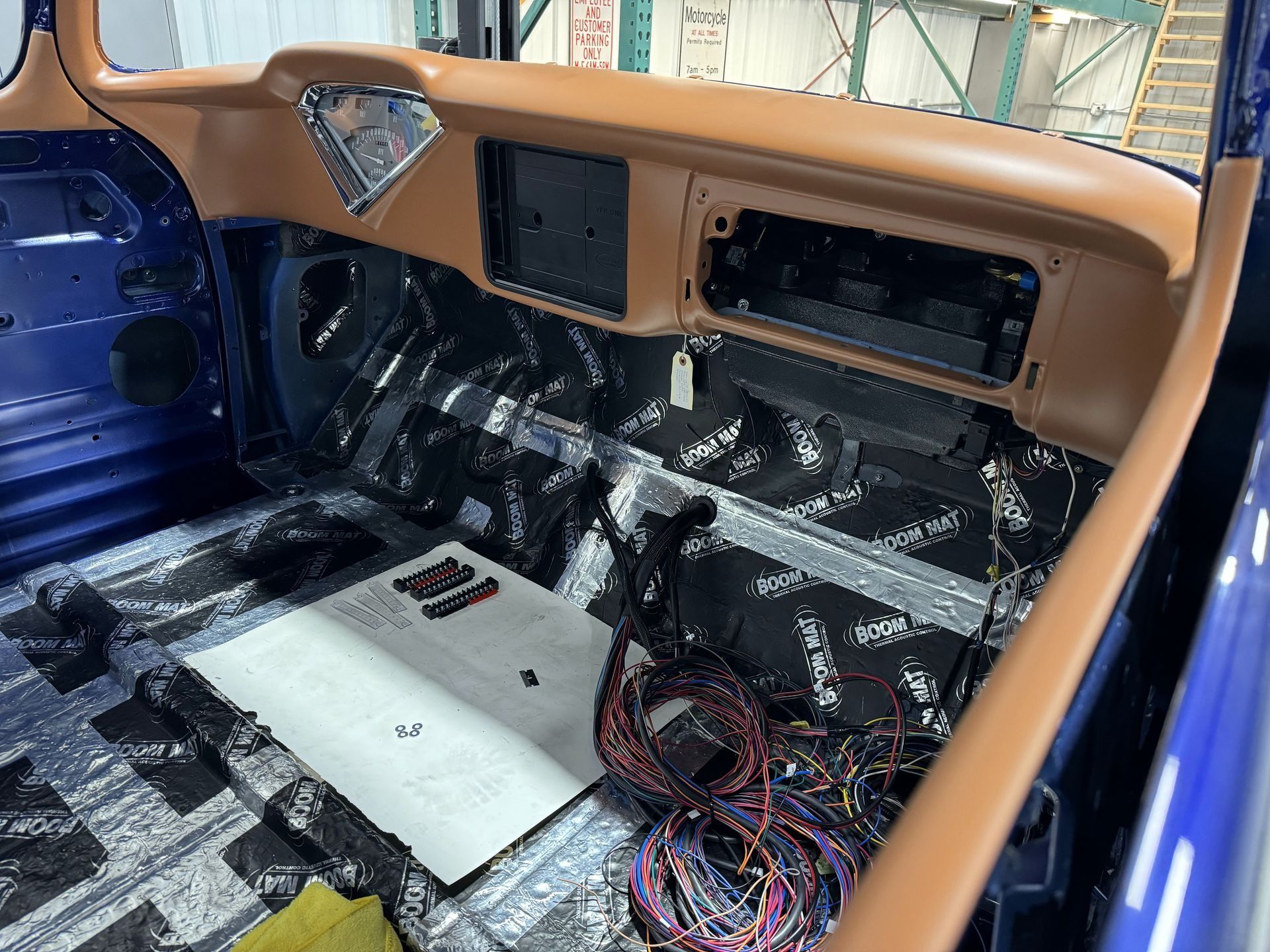 The inside of a blue car with a lot of wires coming out of it.
