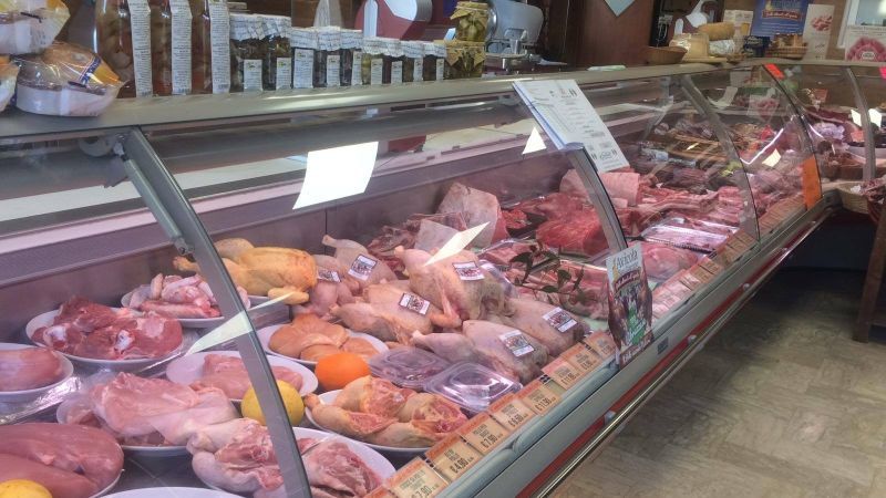banco della macelleria con polli interi e porzionati