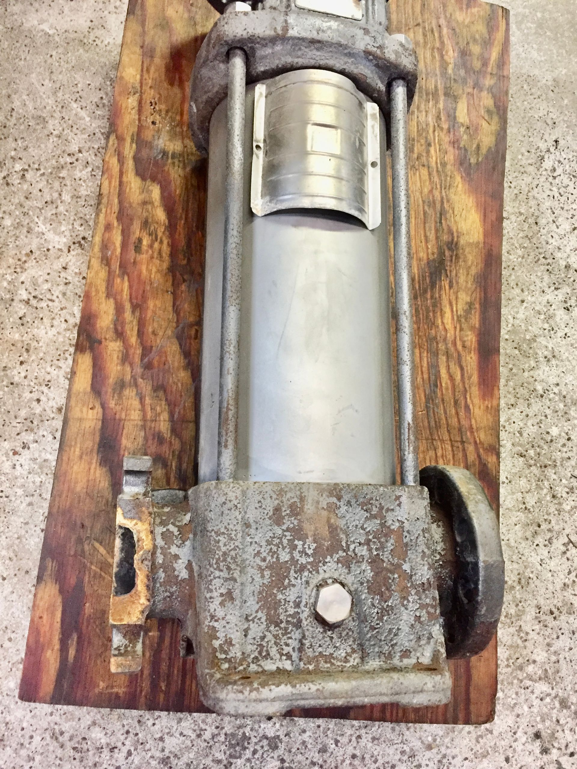 A metal object is sitting on top of a wooden board.