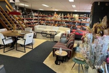 Een woonkamer vol met meubels en tafels in een winkel.