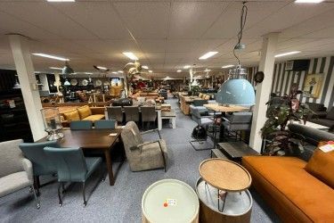 Een grote kamer vol met meubels, tafels en stoelen.