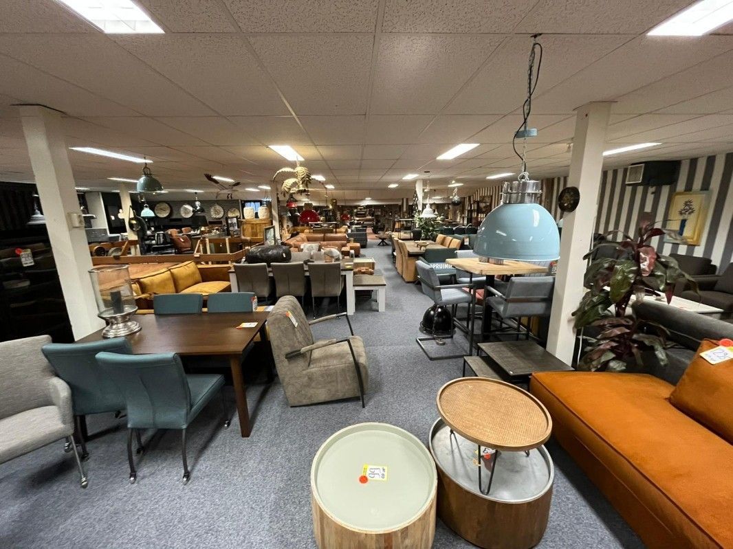 Een grote kamer vol met meubels en tafels.