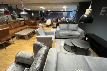 Een woonkamer vol met meubels en salontafels.