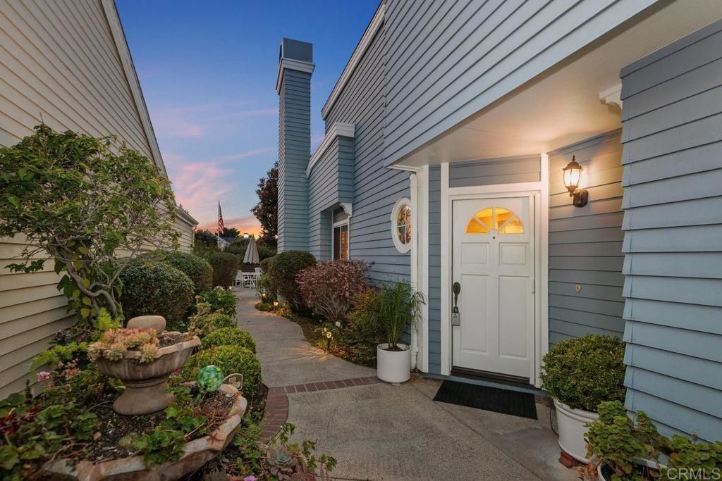 A living room with a couch , chairs , ottoman and a mirror